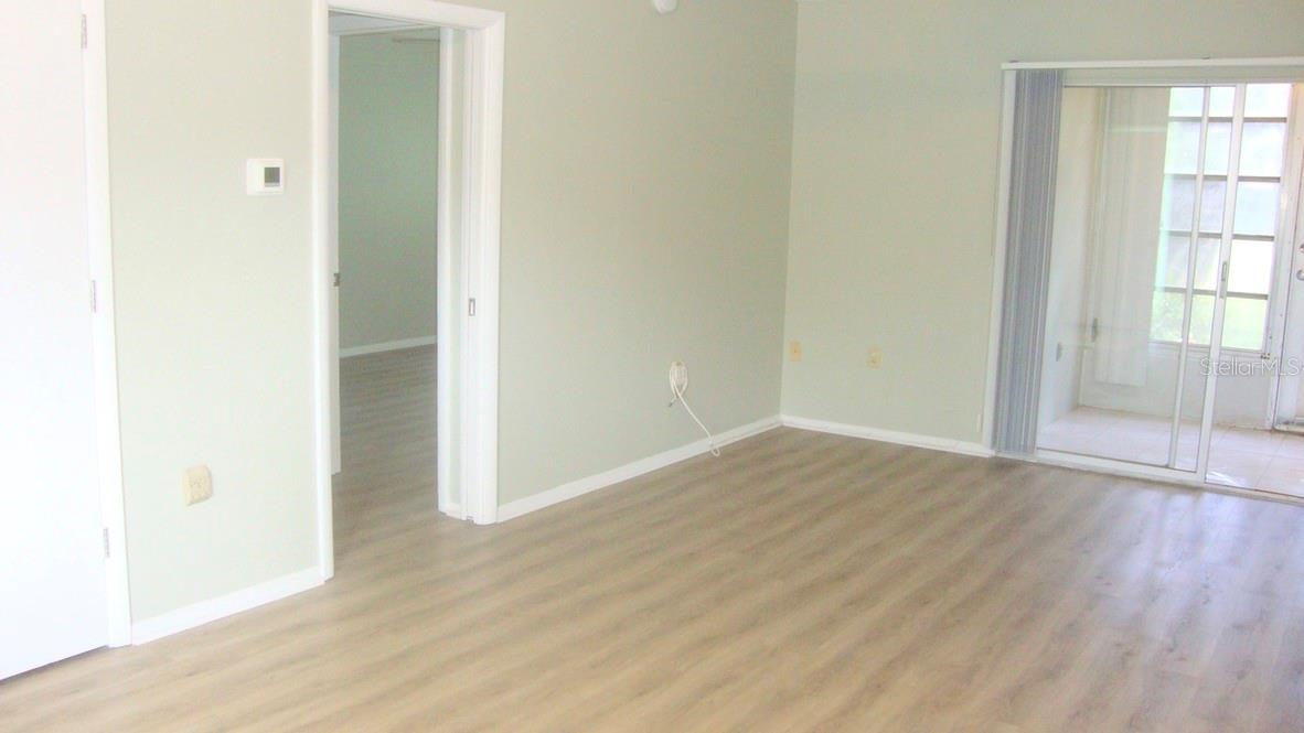 VIEW TO PATIO TO BACKYARD, ENTRANCE FROM LIVING ROOM TO BEDROOM, STORAGE AREA IN LIVING ROOM