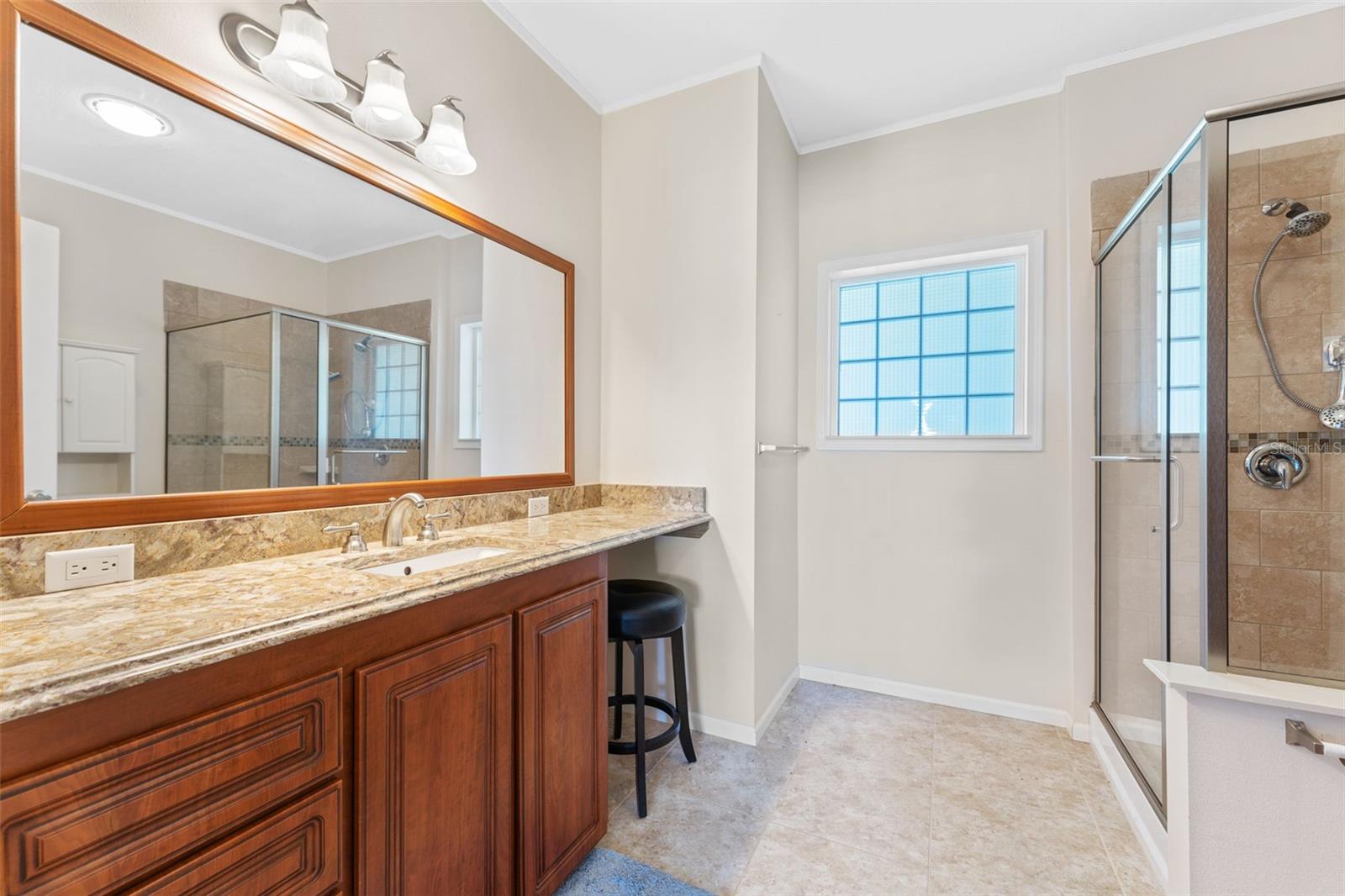 Primary bath with granite counter, tiled walk-in shower, and ceramic tile floor