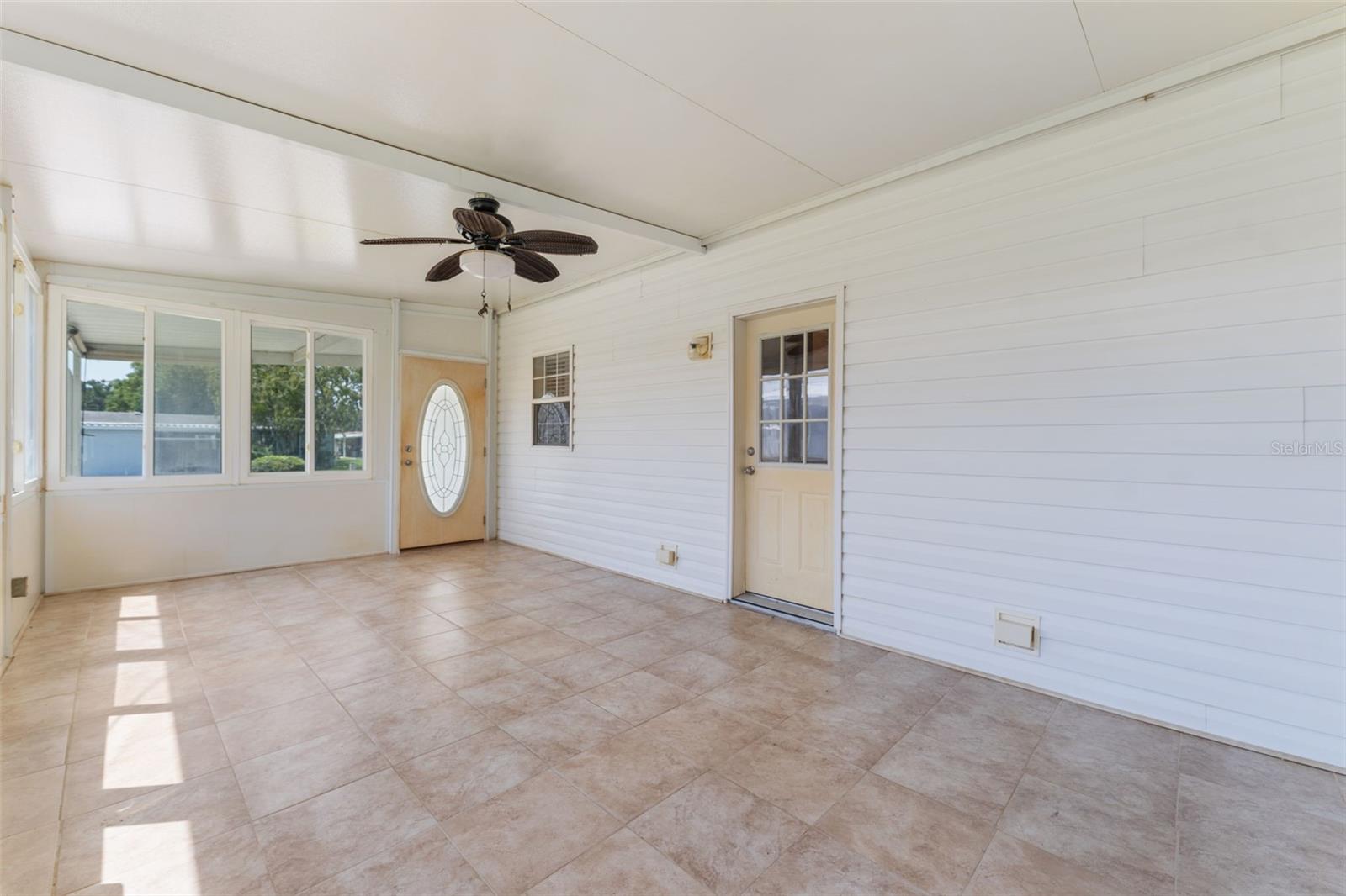 Large Florida room with abundant natural light, ceramic flooring, and ceiling fan