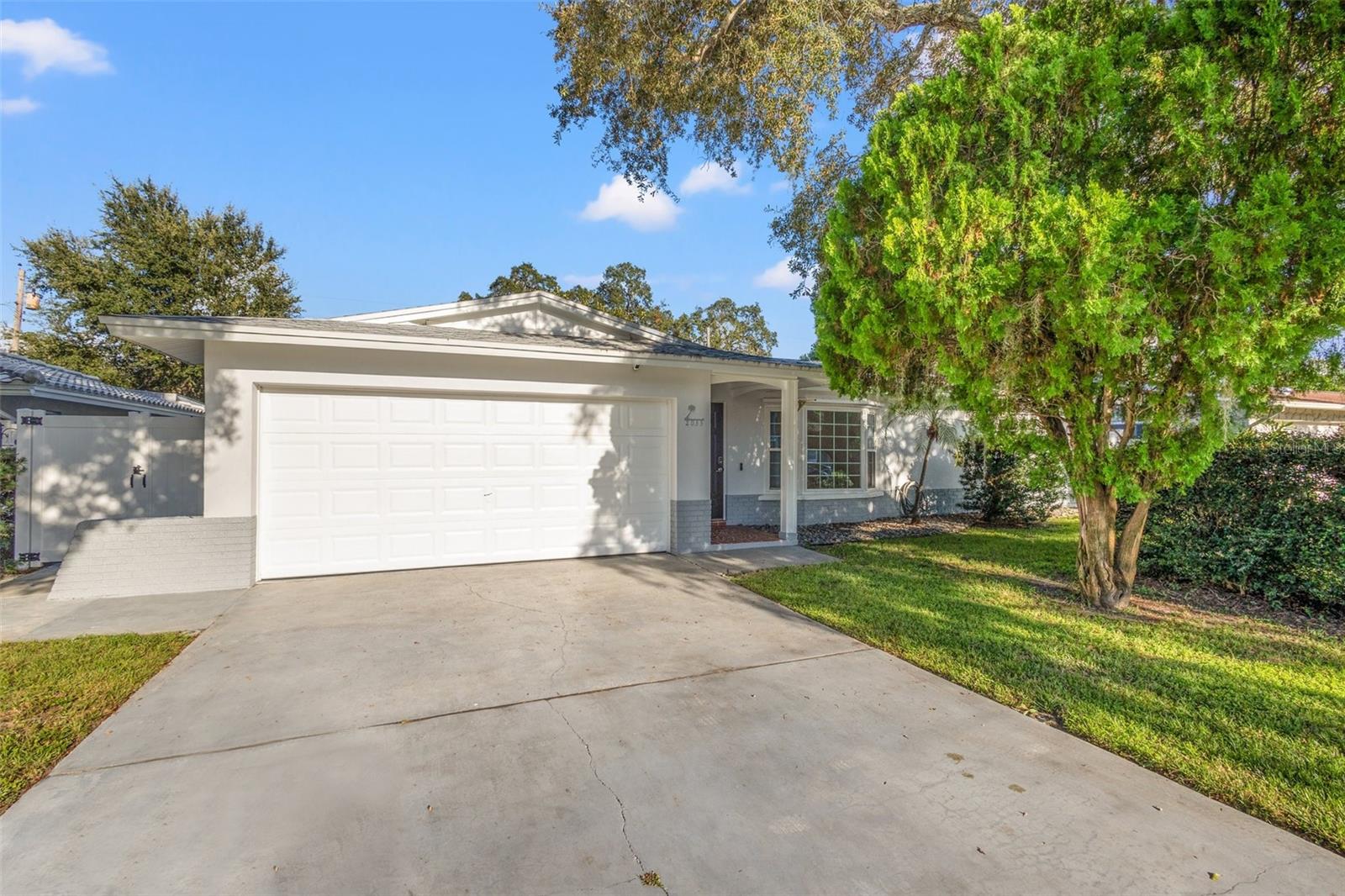 Large driveway, mature and manicured landscaping and 2 car garage