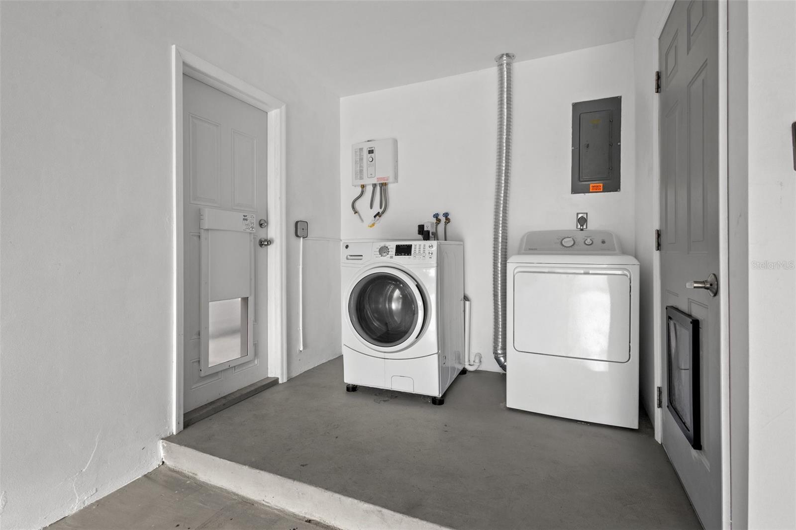 Separate laundry area showing newer washer & dryer and new tankless water heater.