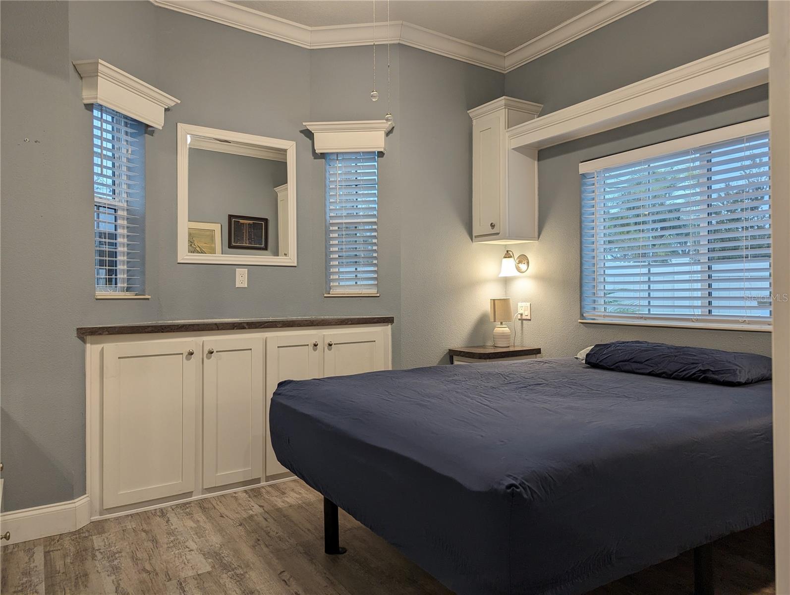 Plenty of cabinets in the bedroom. Crown molding adorns the wall and ceiling.