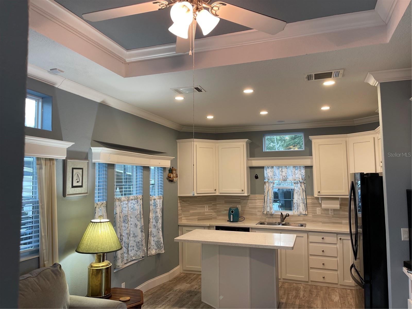 Valances, blinds, and drapes in kitchen and living room.