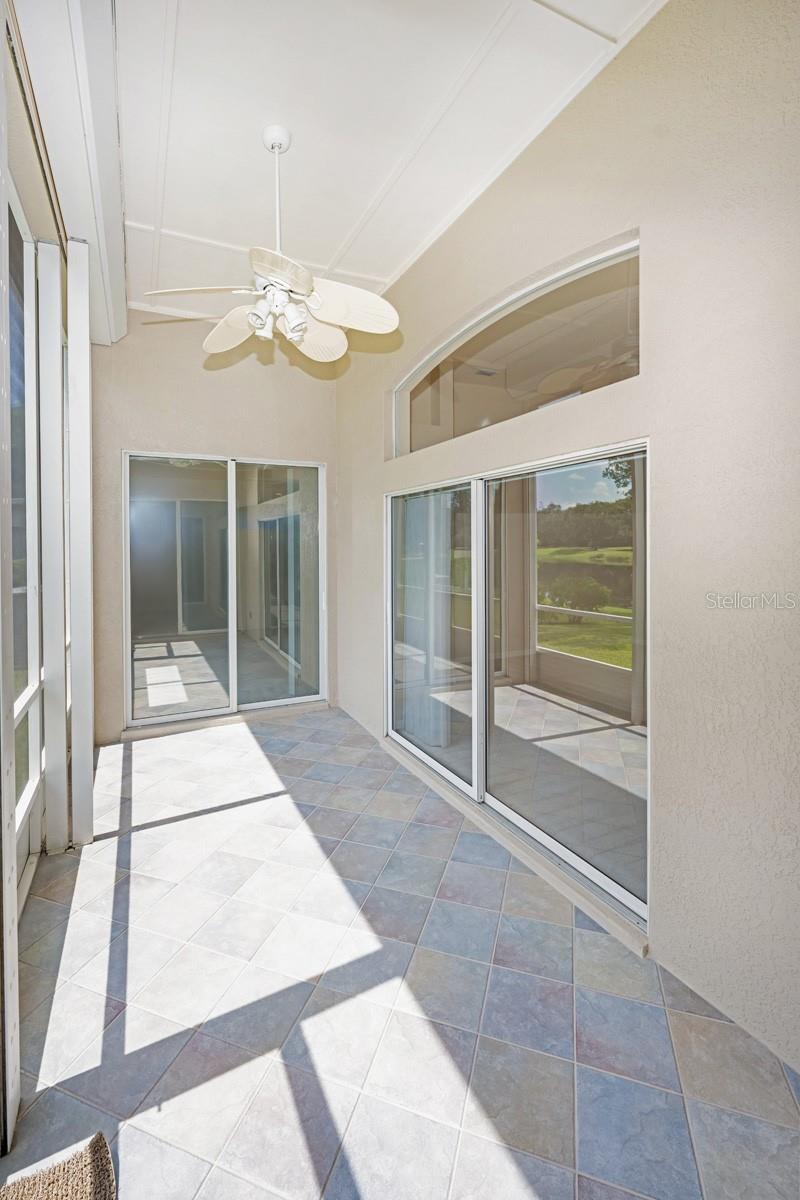 Oversize rear lanai with slider leading from kitchen, family room, and main bedroom