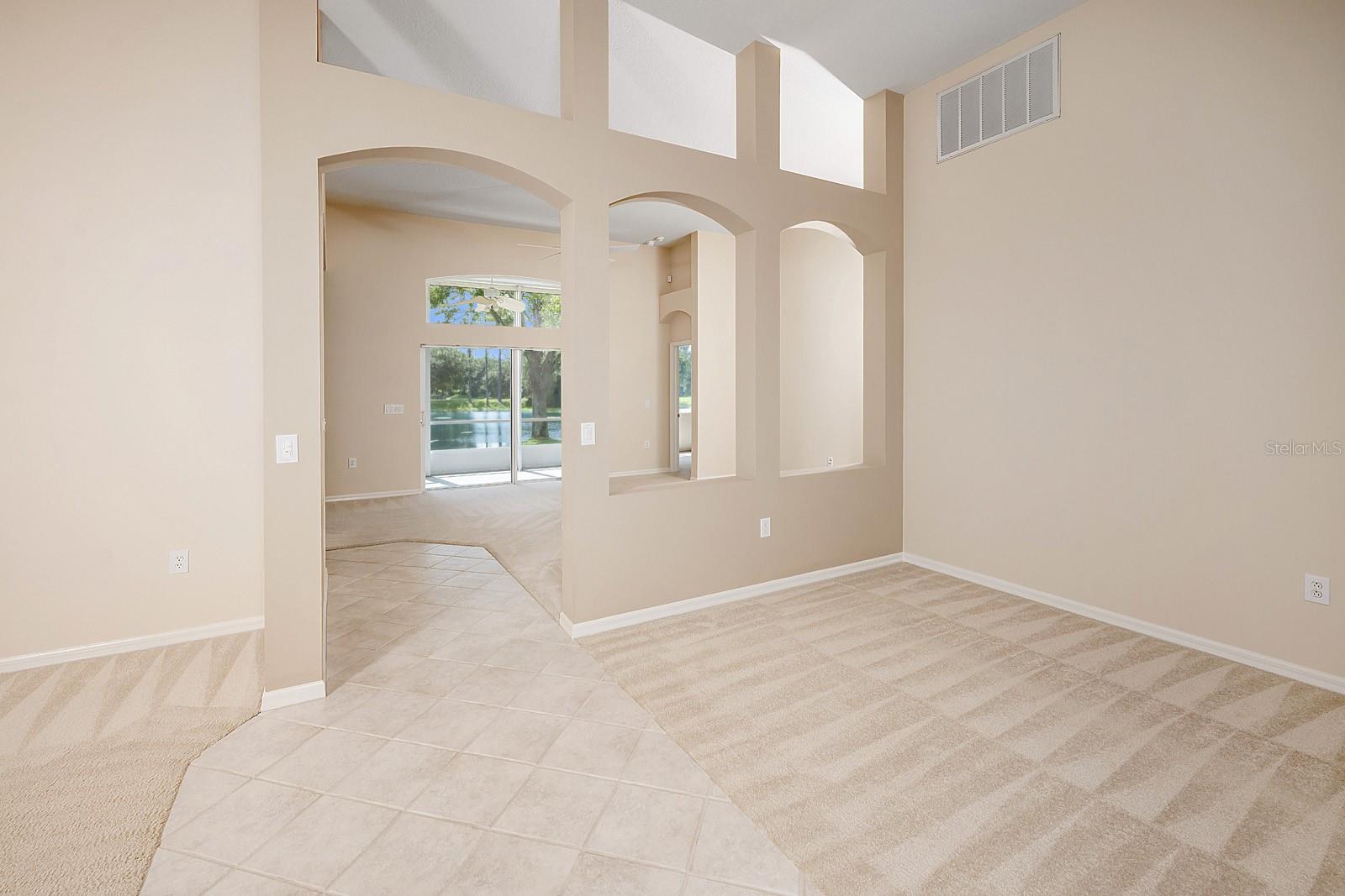 Living room, Dining room, Family room with view to lanai and pond.