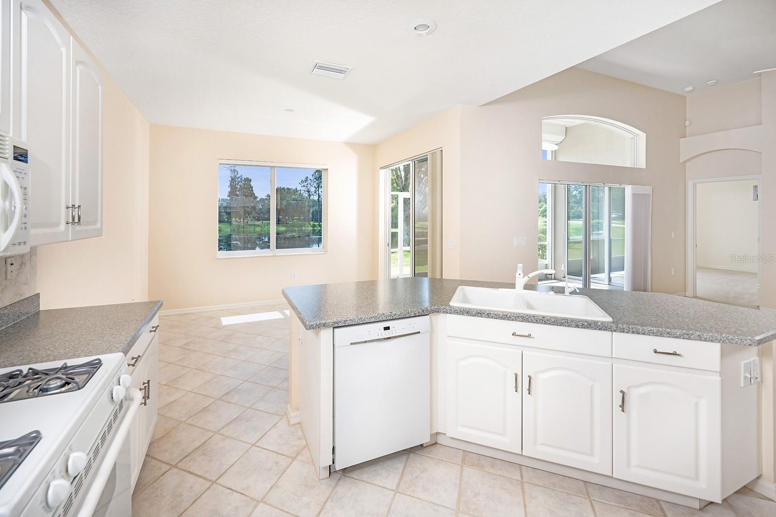 Kitchen with pond view. Picture window, transom, and sliders are newly tinted.