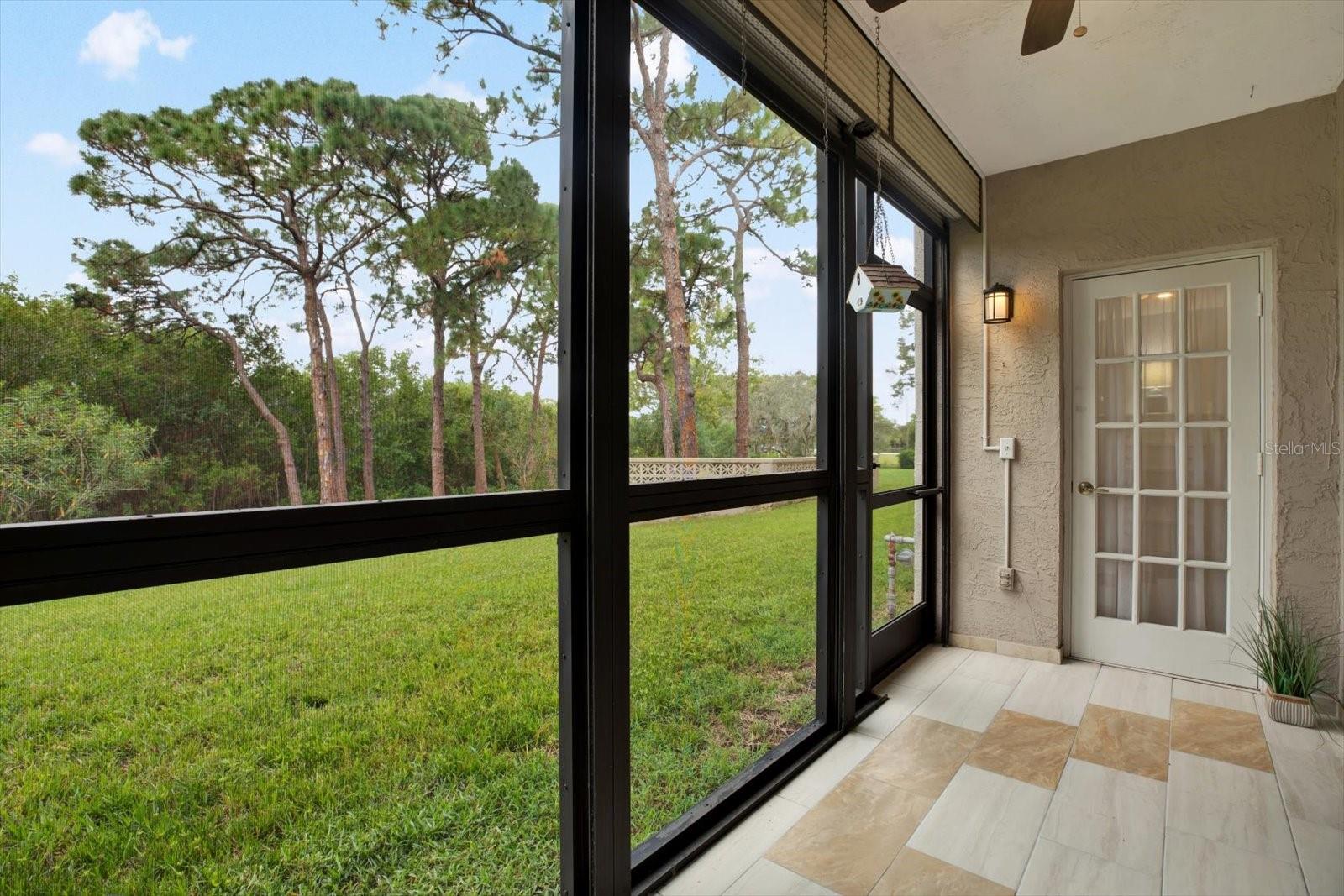 Screened in patio WITH hurricane shutters overlooking the trees and greenery