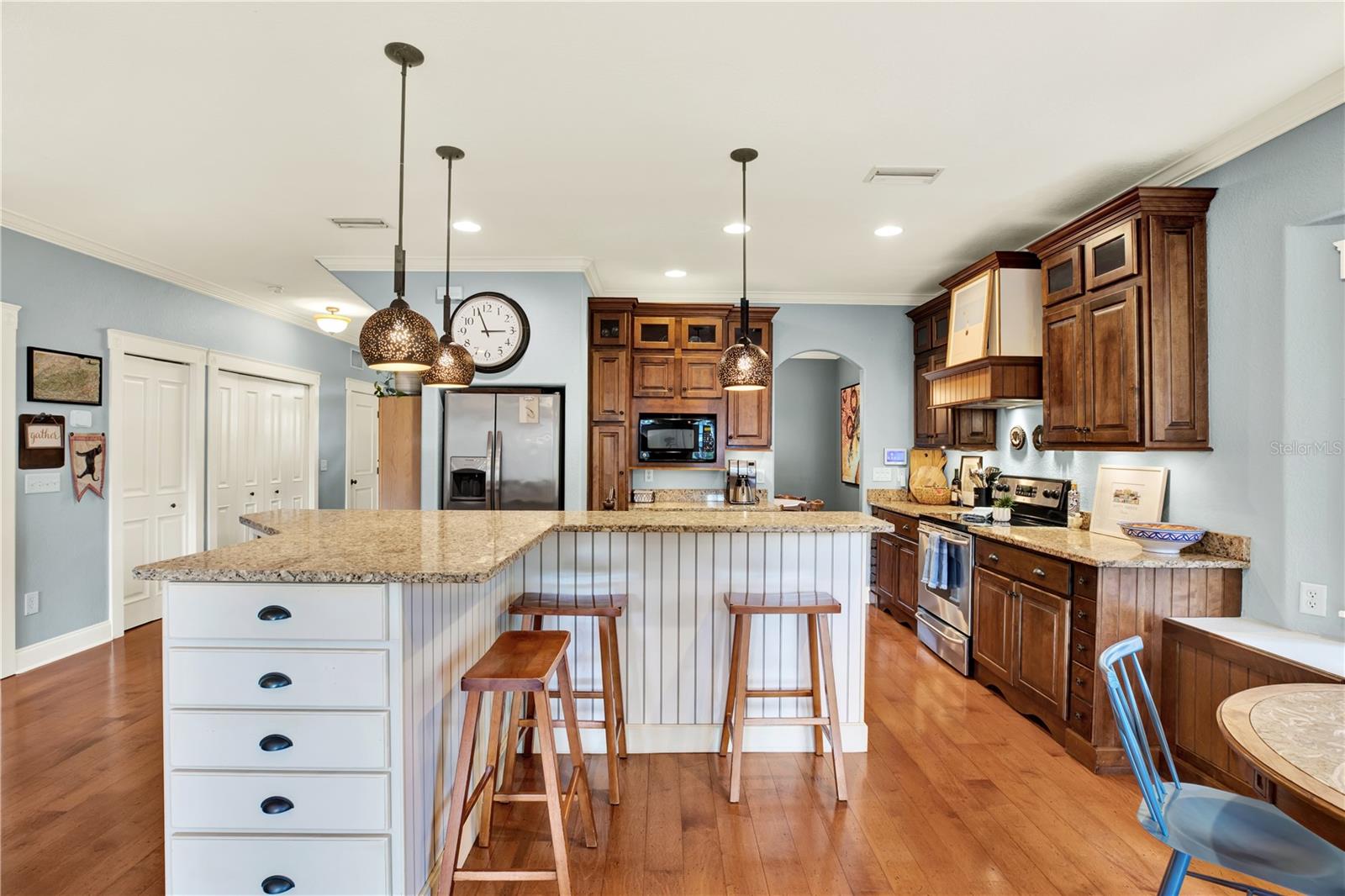 Warm wood tones play well with the cream cabinetry and brass light fixtures