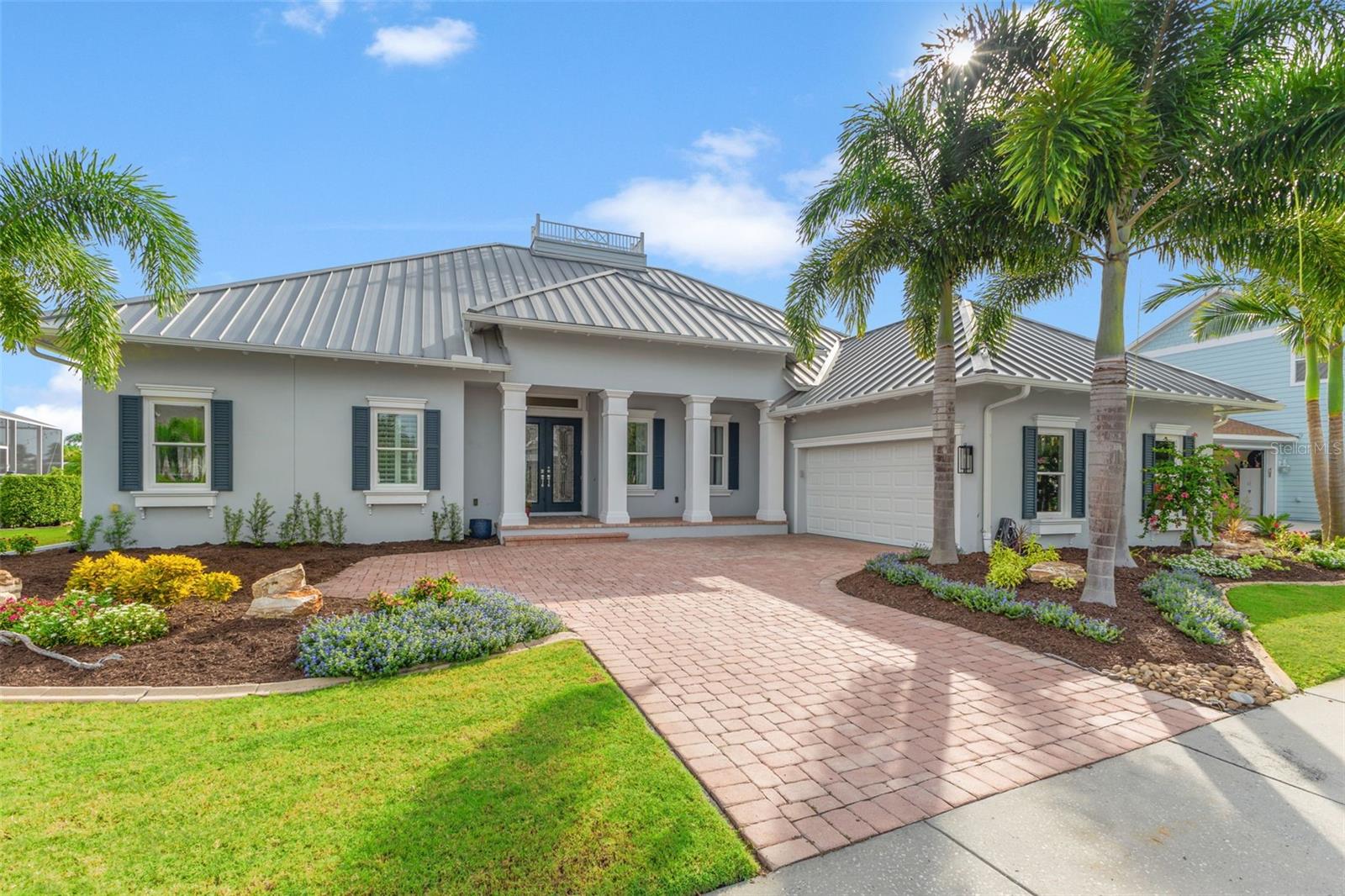 Front of Home with side entry garage, metal roof, new landscaping and pavers