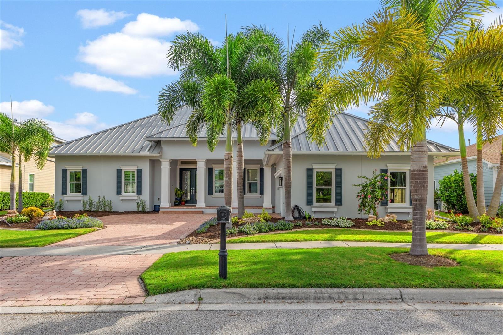 Front of Home with side entry garage, metal roof, new landscaping and pavers