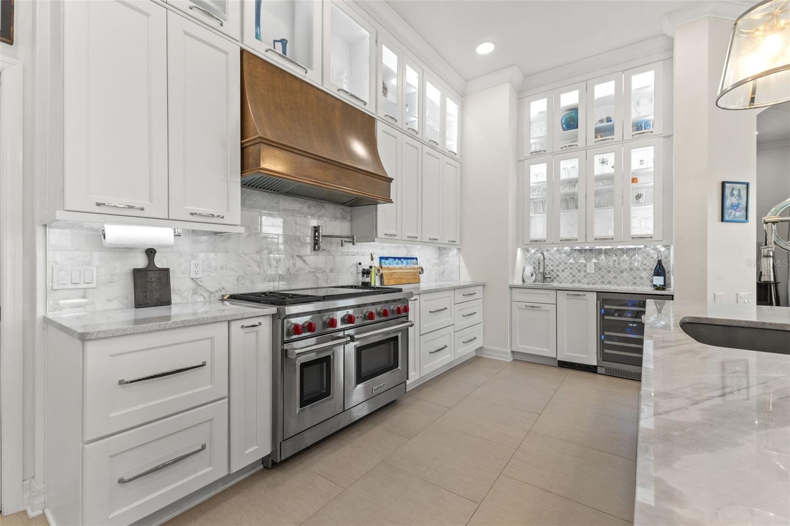 Stunning chef kitchen with stacked cabinets, built in oven, gas cook top, duel refrigerators, marble and granite countertops