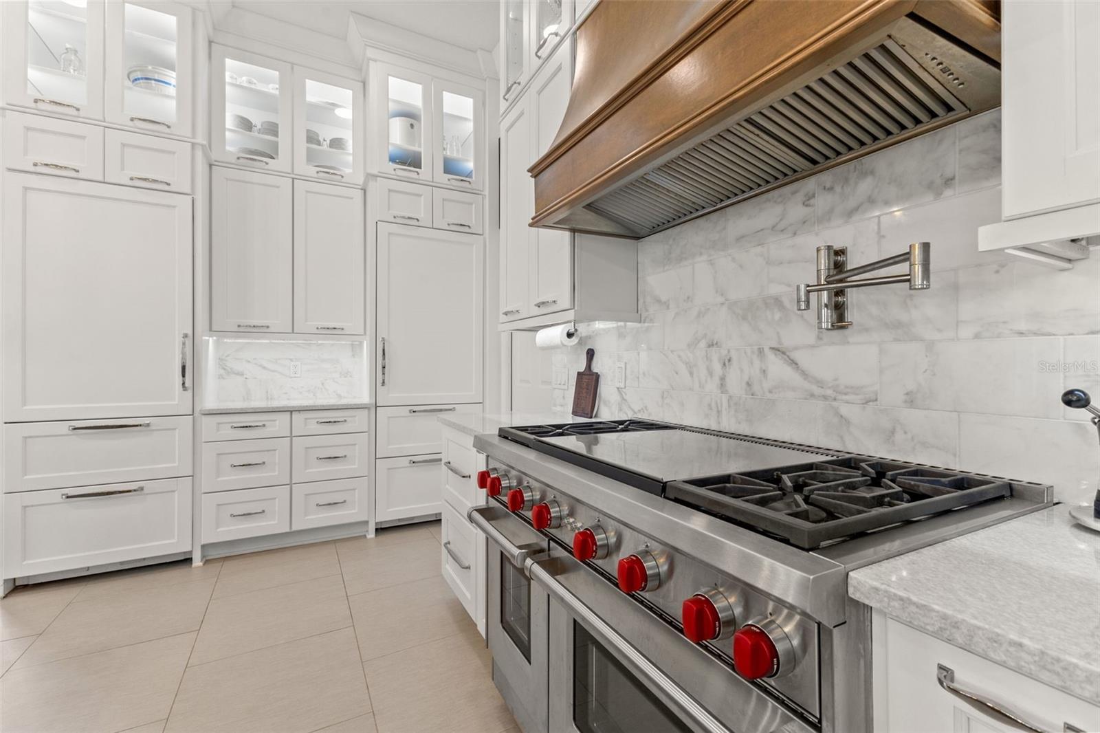 Stunning chef kitchen with stacked cabinets, built in oven, gas cook top, duel refrigerators, marble and granite countertops