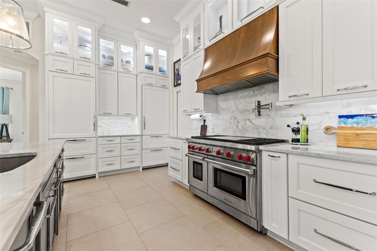 Stunning chef kitchen with stacked cabinets, built in oven, gas cook top, duel refrigerators, marble and granite countertops