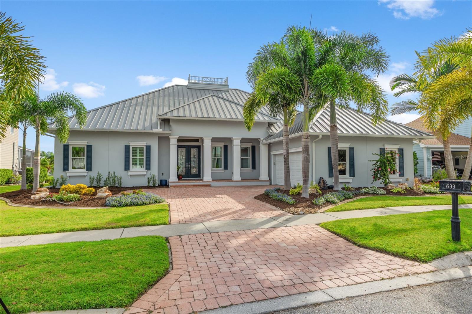 Front of Home with side entry garage, metal roof, new landscaping and pavers