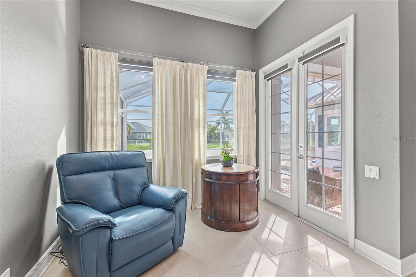 Sitting area in primary bedroom with view to pool