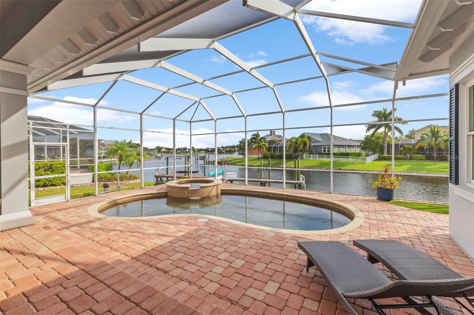 Beautiful heated pebble tech pool, spa with gorgeous pavers and view to waterfront