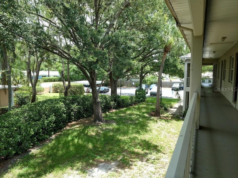 Walkway to entry door and view of greenspace