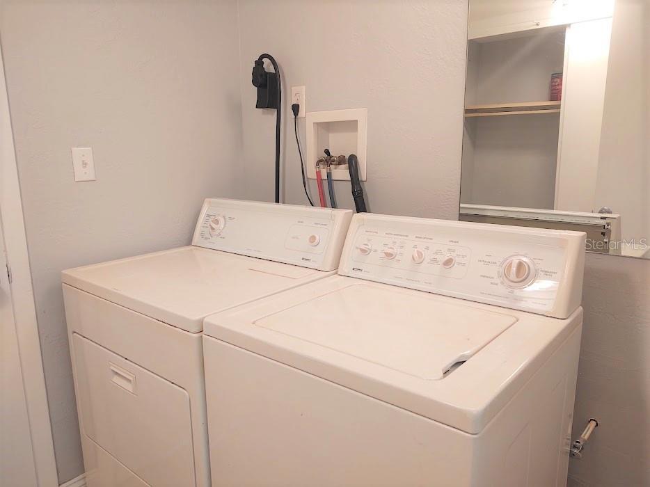 Laundry room with view in mirror of closet space