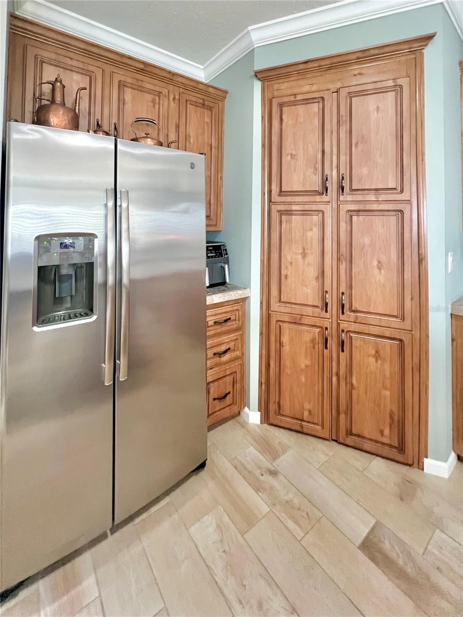 Large pantry next to refrigerator