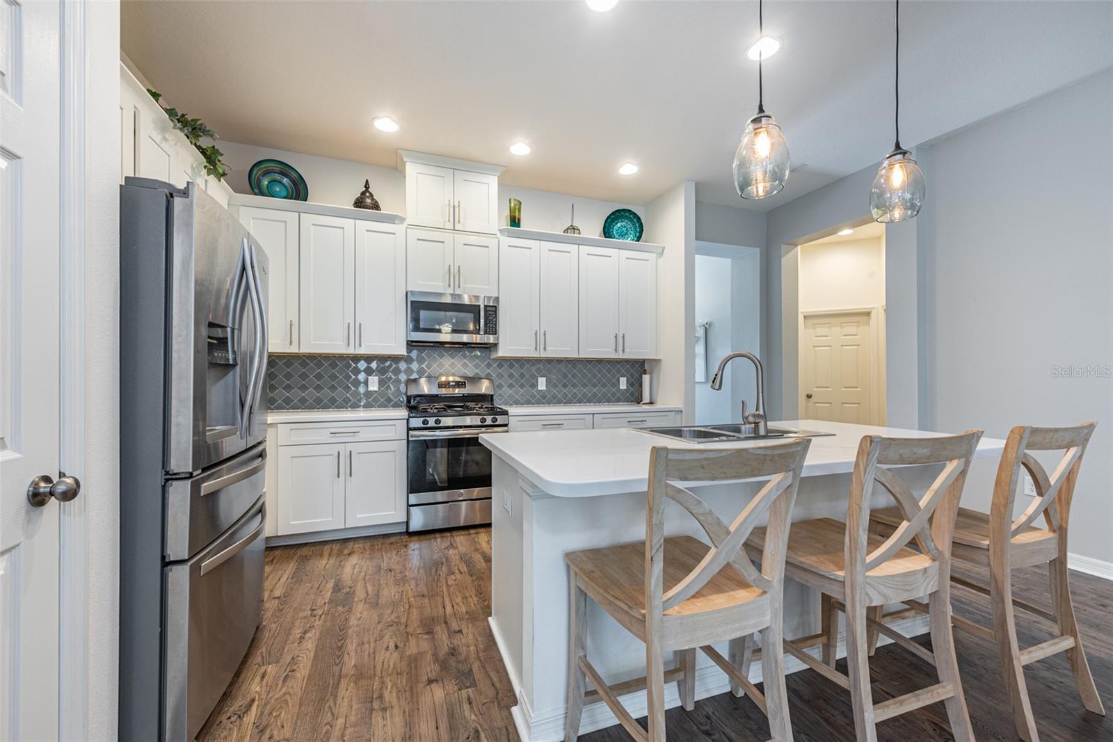 Durable corian countertops, stylish glass tile backsplash and stainless steel appliances, including a gas oven with a five-burner cast iron stove, dishwasher, refrigerator and microwave.