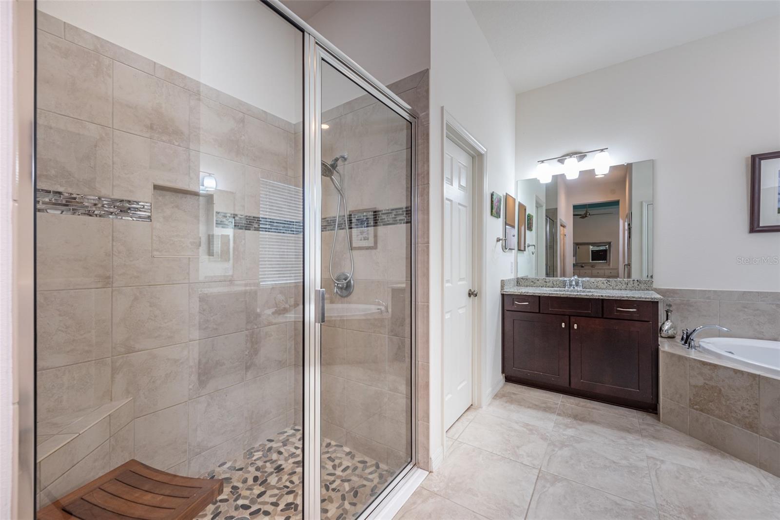 The owner’s ensuite bathroom features dual vanities, a spacious tile shower, and a separate soaking tub.