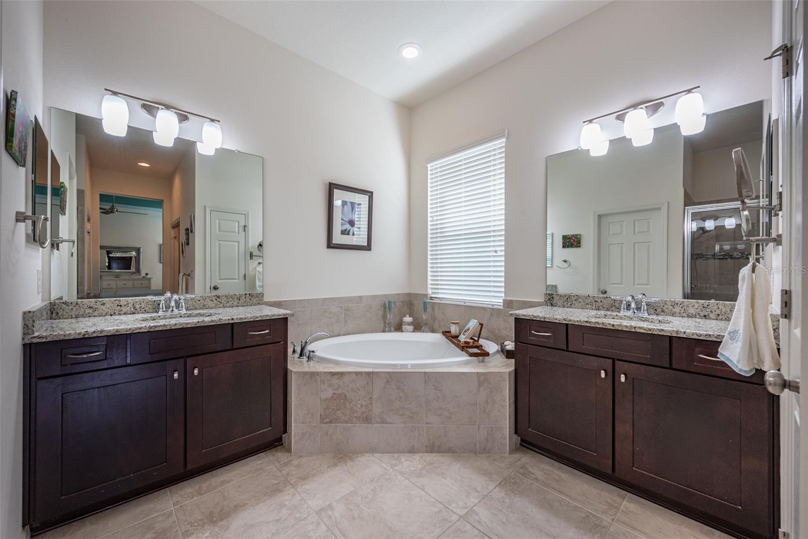 This bathroom retreat features dual vanities with plenty of storage and granite counters.