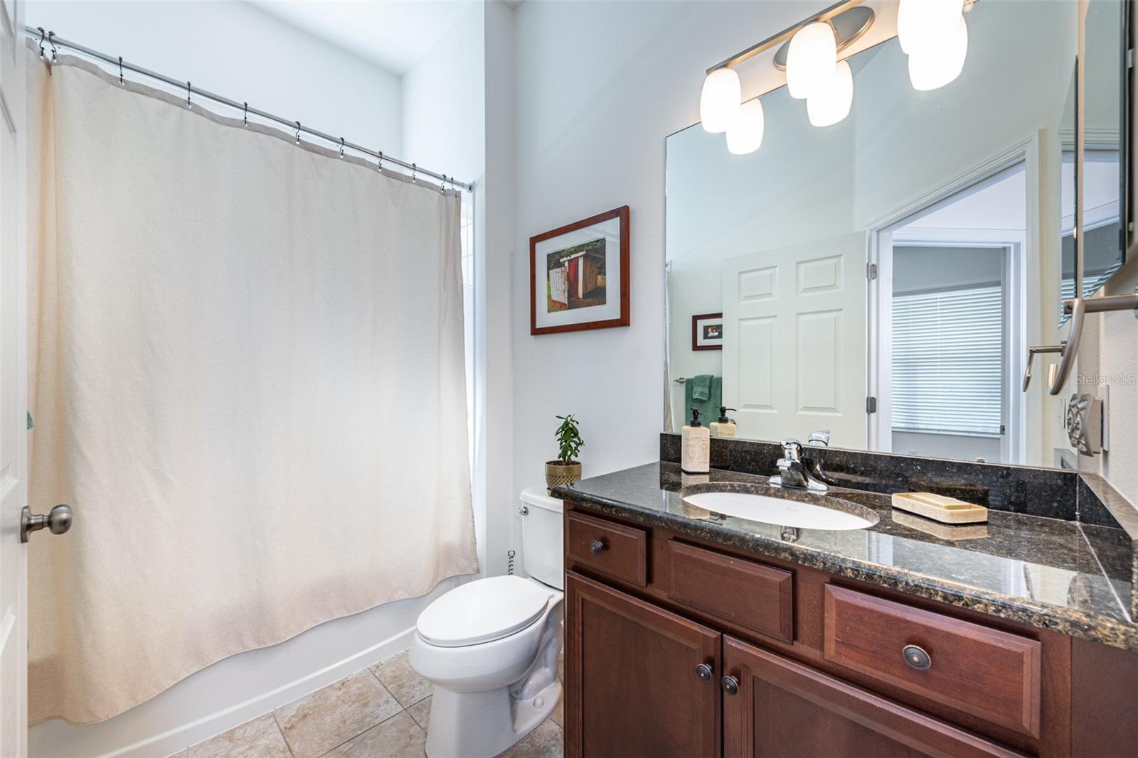 Bedrooms 2 and 3 are thoughtfully located away from the primary suite for privacy, with a full bath that includes a granite countertop vanity and a tub/shower combo