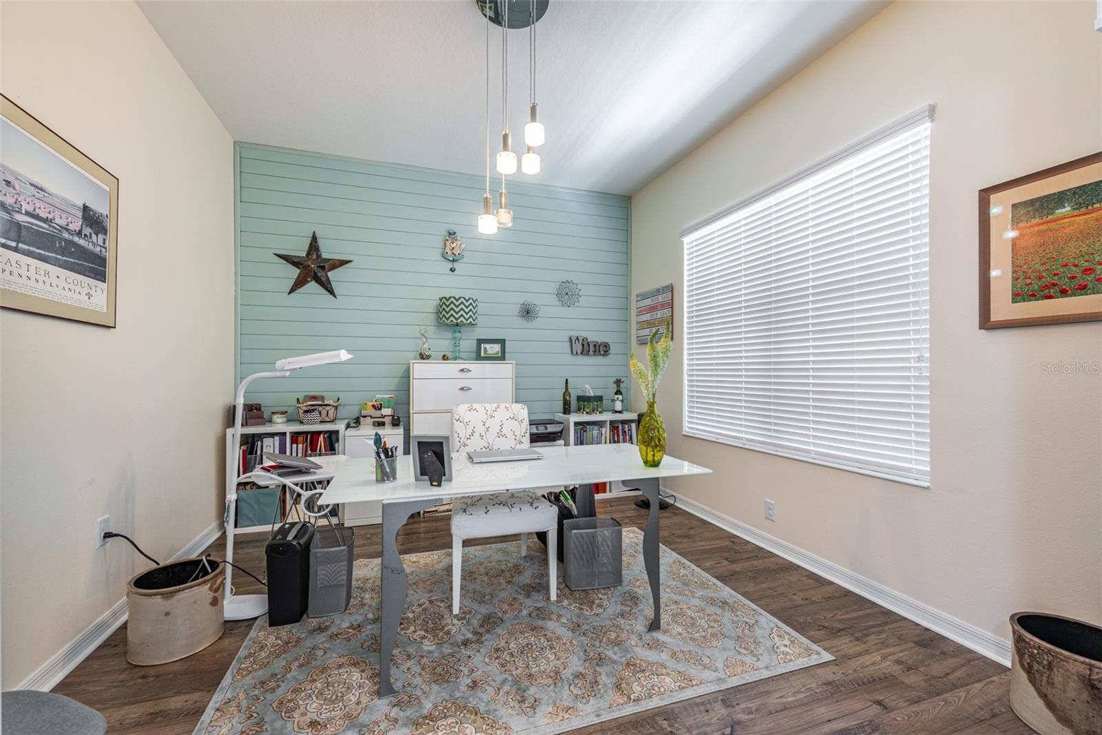 12'x13' office/den at the front of the home with built-in shelving.