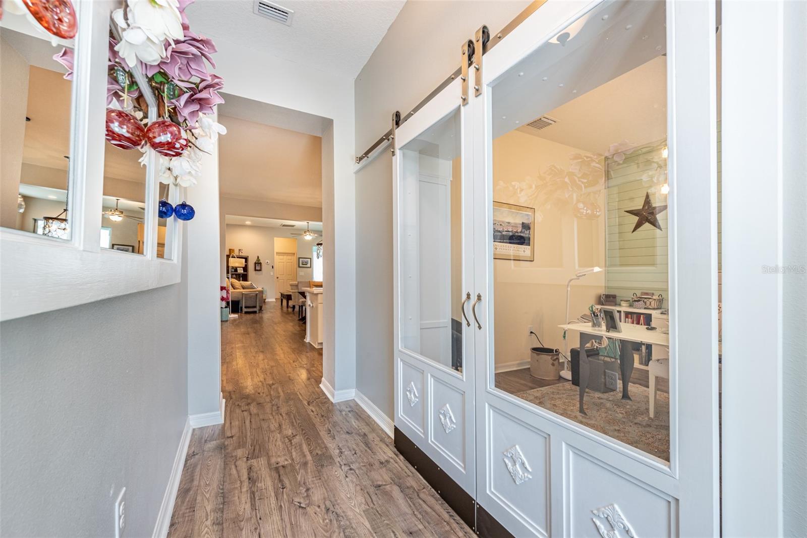 Just inside the leaded glass front door you will see an office/den behind sliding glass barn doors.