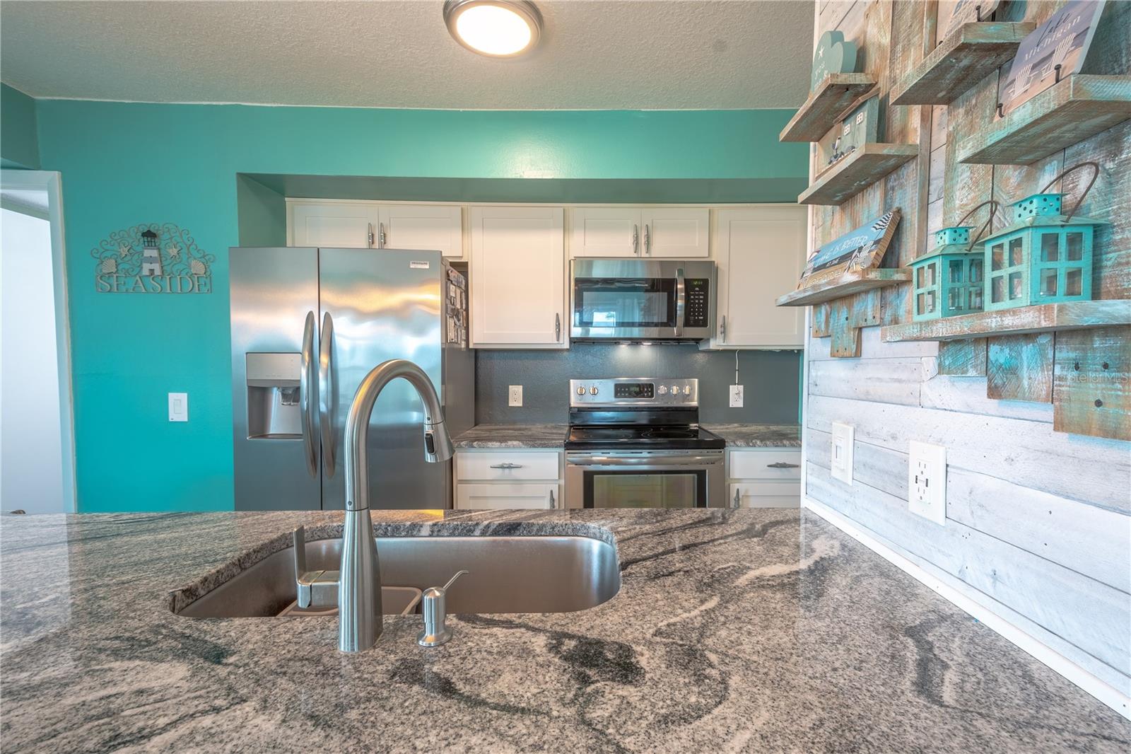 The granite counter mimics sand, keeping with the coastal theme.