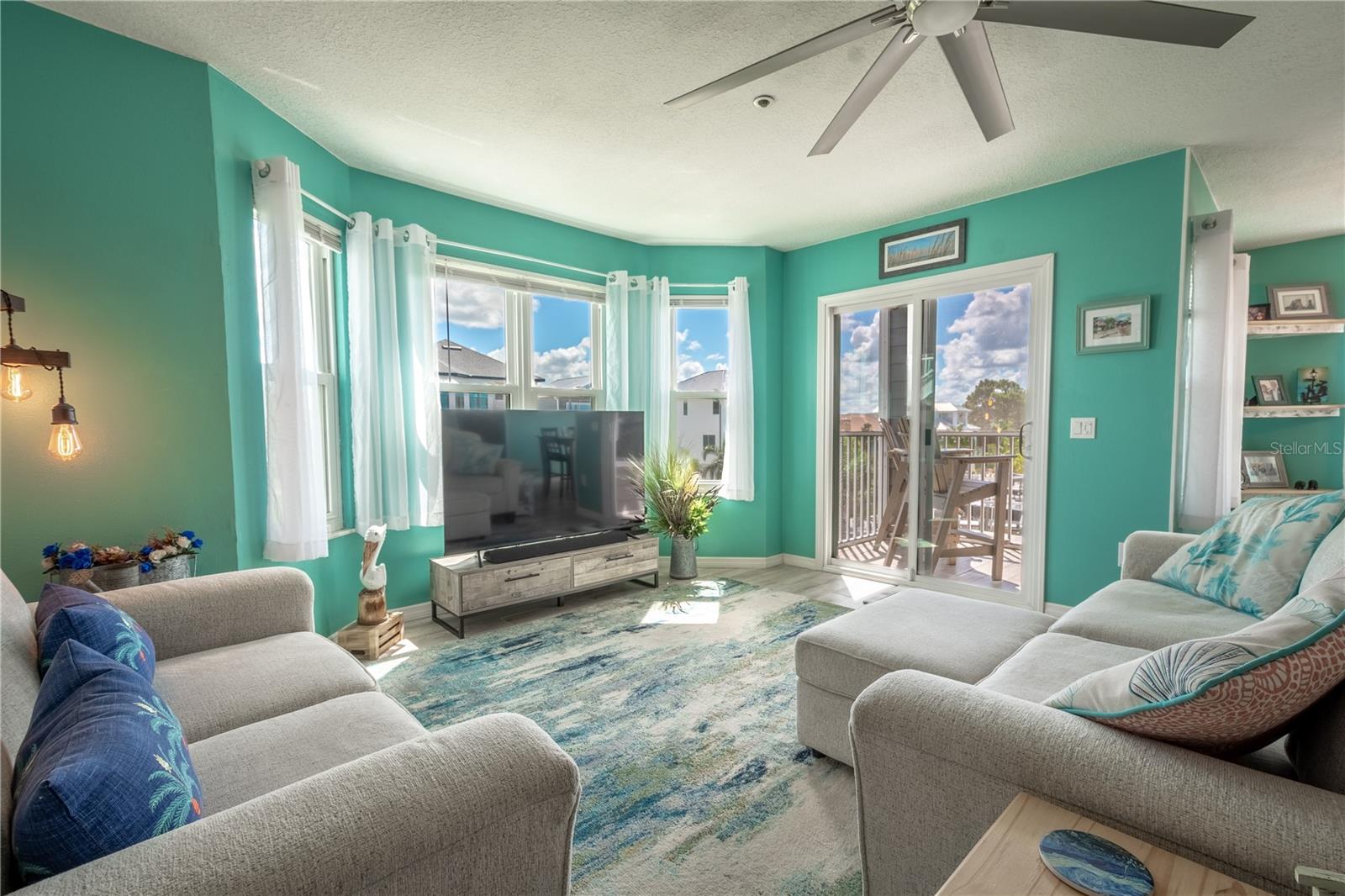 The living room is spacious, windows and doors framing water views.