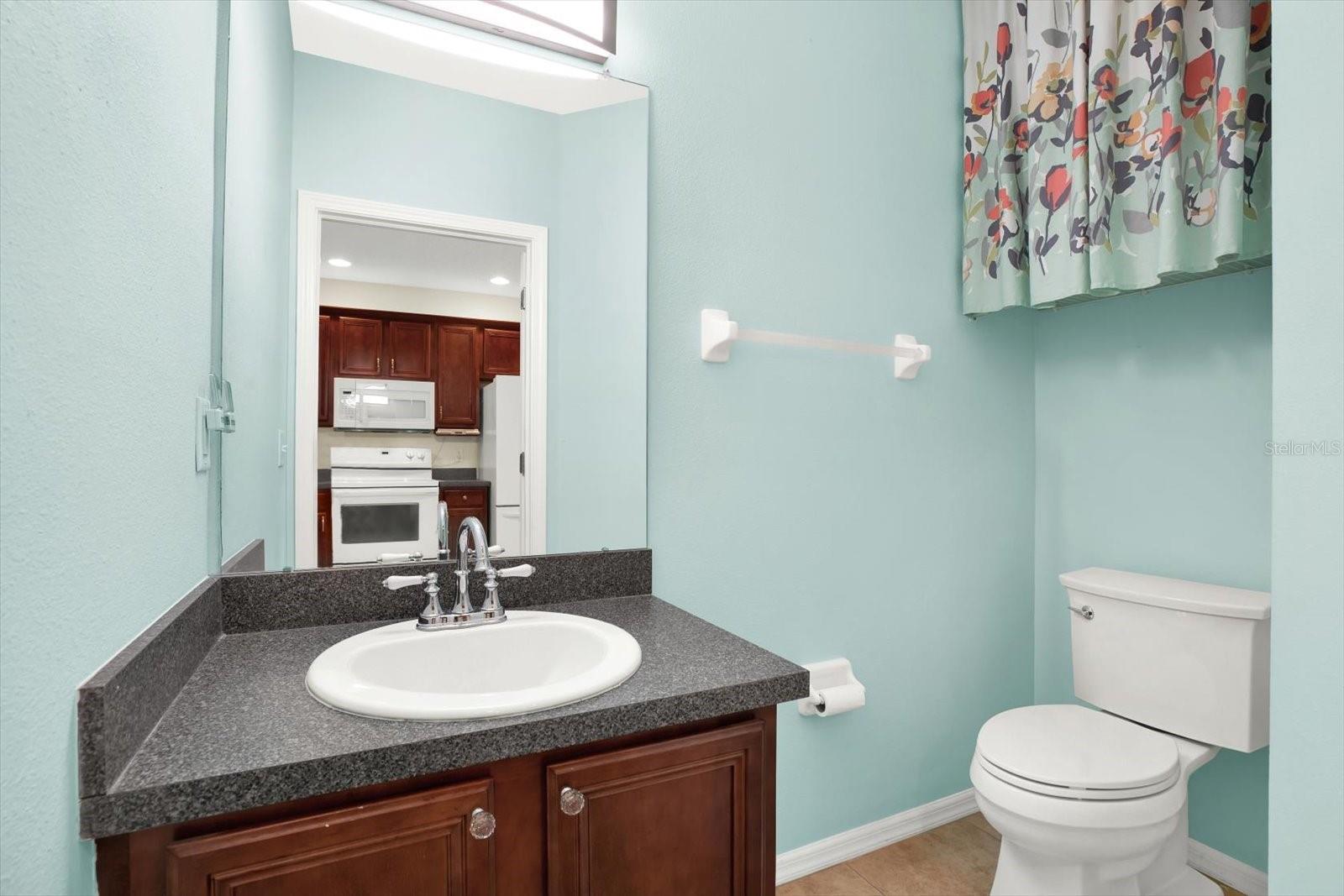 Conveniently located just off the kitchen, this stylish half bath features modern fixtures and a sleek design. Its proximity adds practicality for guests while maintaining privacy, making it a perfect addition to the home's functional layout.