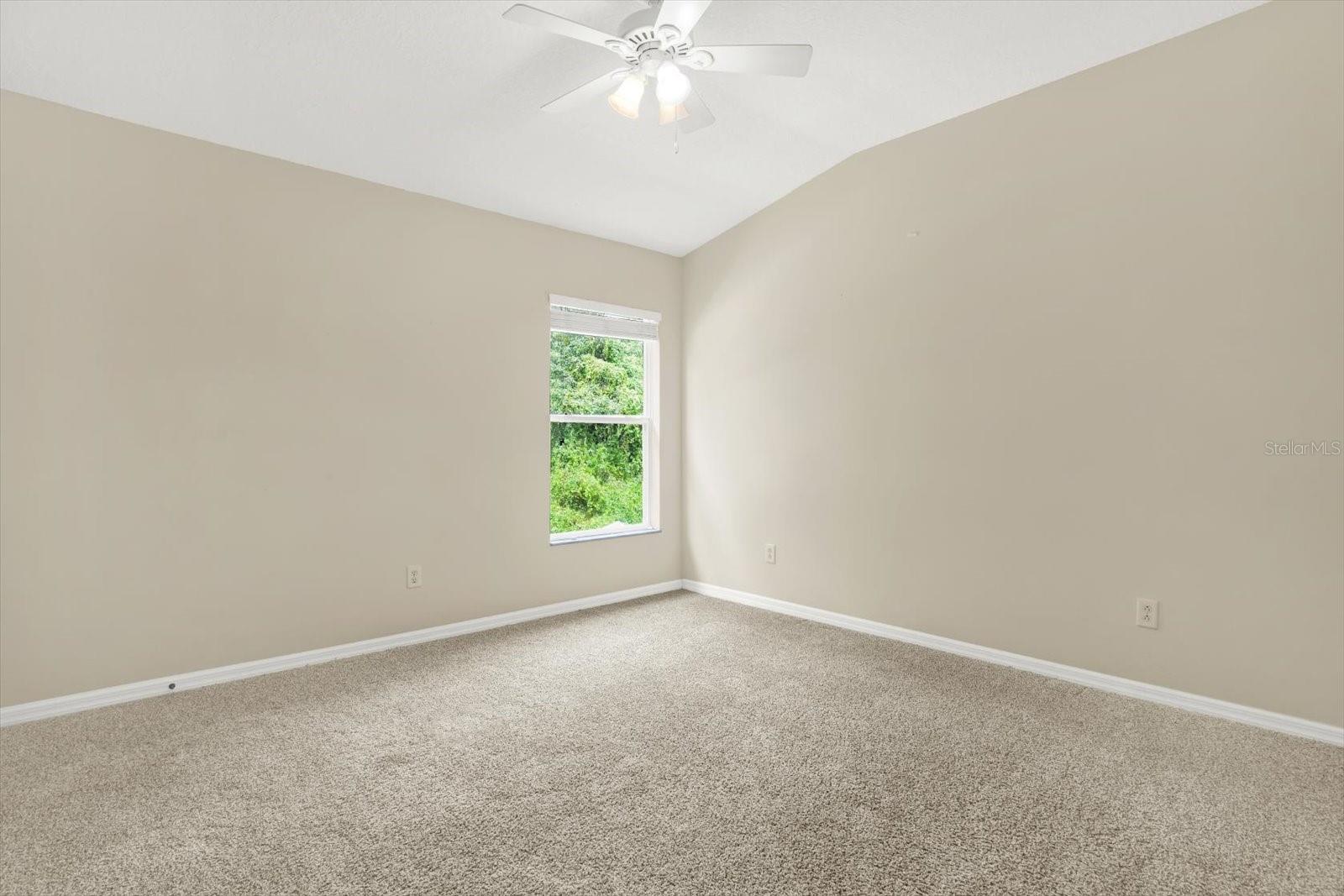 This comfortable second-floor bedroom features plush carpet flooring for a cozy feel and a spacious walk-in closet, offering ample storage. The room's generous size and thoughtful design make it an ideal space for relaxation or a guest retreat.