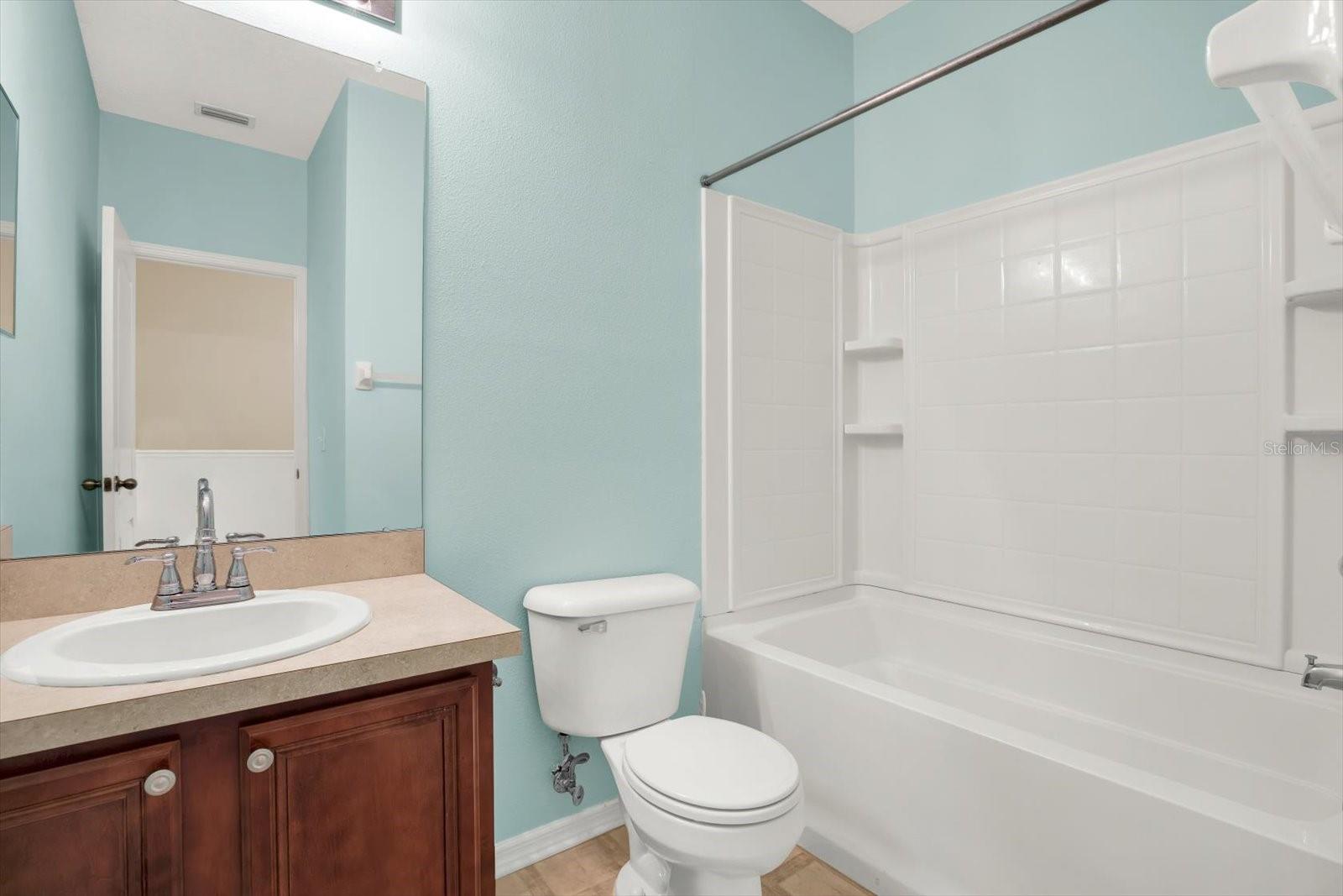 This well-appointed second-floor bathroom features a full bathtub, perfect for unwinding after a long day. With sleek fixtures, a large vanity, and plenty of counter space, this bathroom offers both comfort and practicality, making it an ideal space for daily routines.