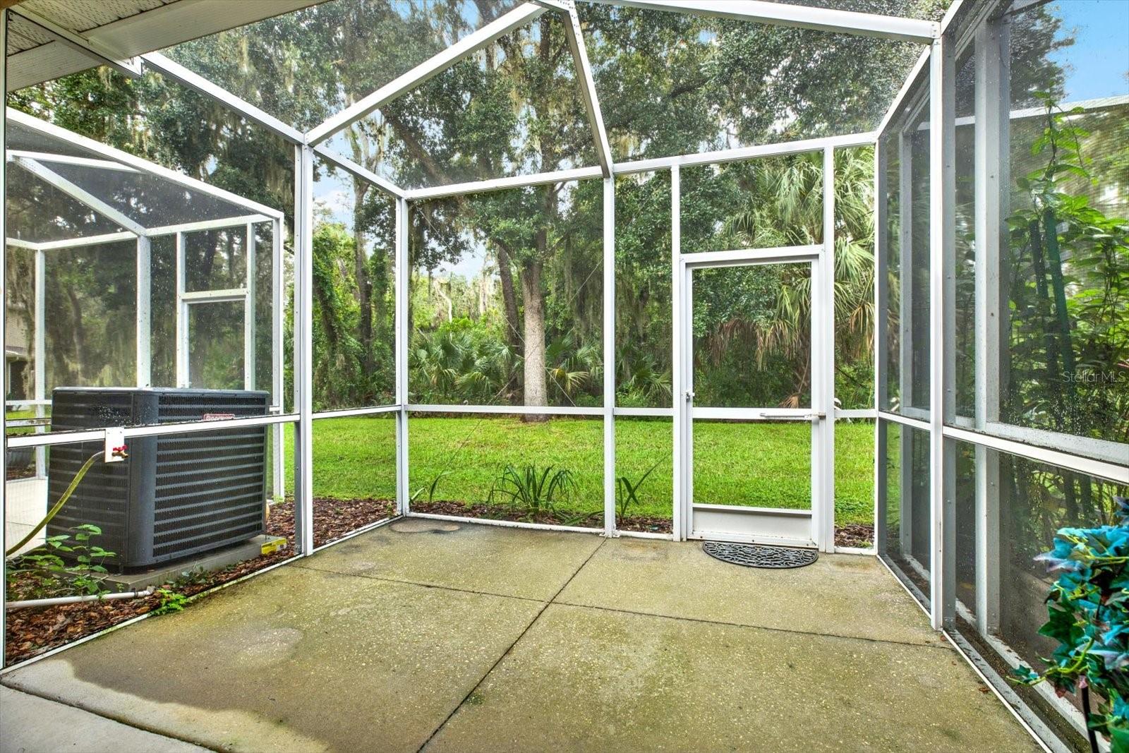 Enjoy the spacious lanai that overlooks the peaceful woods. This inviting outdoor area is perfect for relaxing or entertaining, with plenty of room for seating. It's a great spot to sip your morning coffee or unwind in the evening while taking in the natural beauty around you.