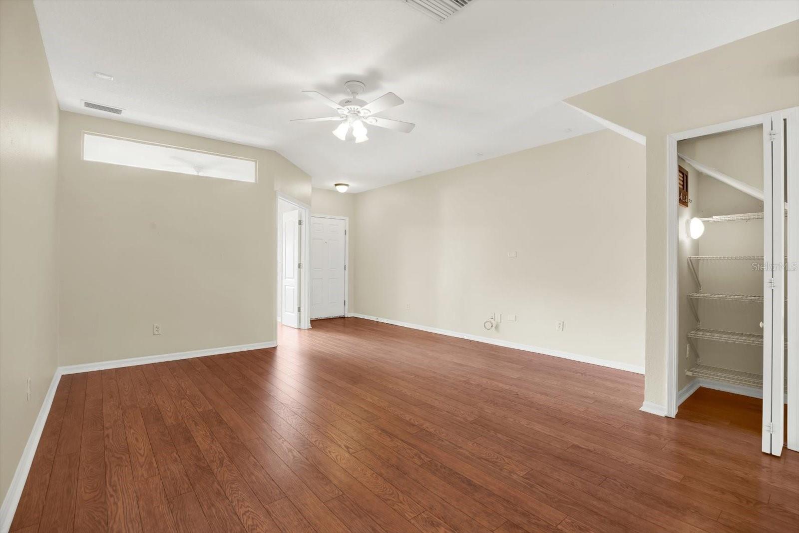 This spacious living room and dining room combo offers an open-concept design, seamlessly connecting to the kitchen for easy entertaining and flow. The rich wood flooring adds warmth and sophistication, while the layout maximizes space and functionality. A clever under-stair storage area is easily accessible, providing extra storage without sacrificing style.