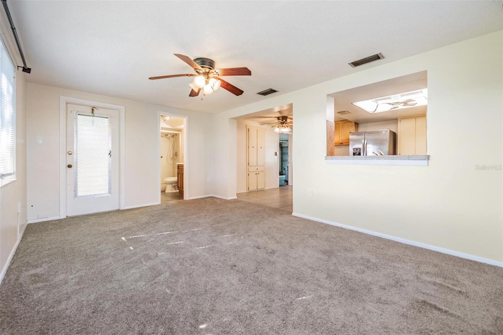 Photo of bonus room showing the door to lanai, bathroom, and you can see the door leading to the garage is open if you zoom...