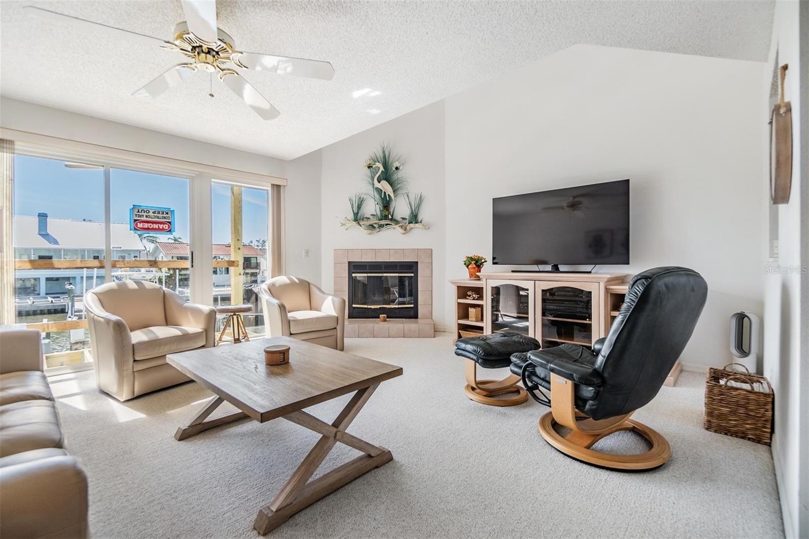 Spacious living room with fireplace, triple sliders lead to your covered balcony and WATER VIEWS!