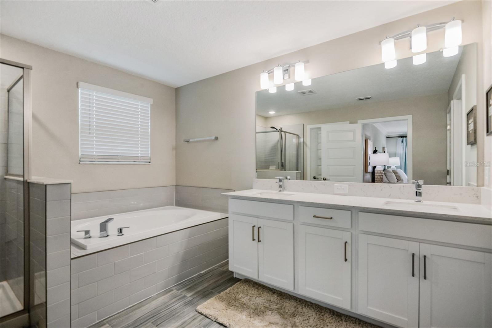 Large ensuite primary bathroom features dual sinks, garden tub and separate shower