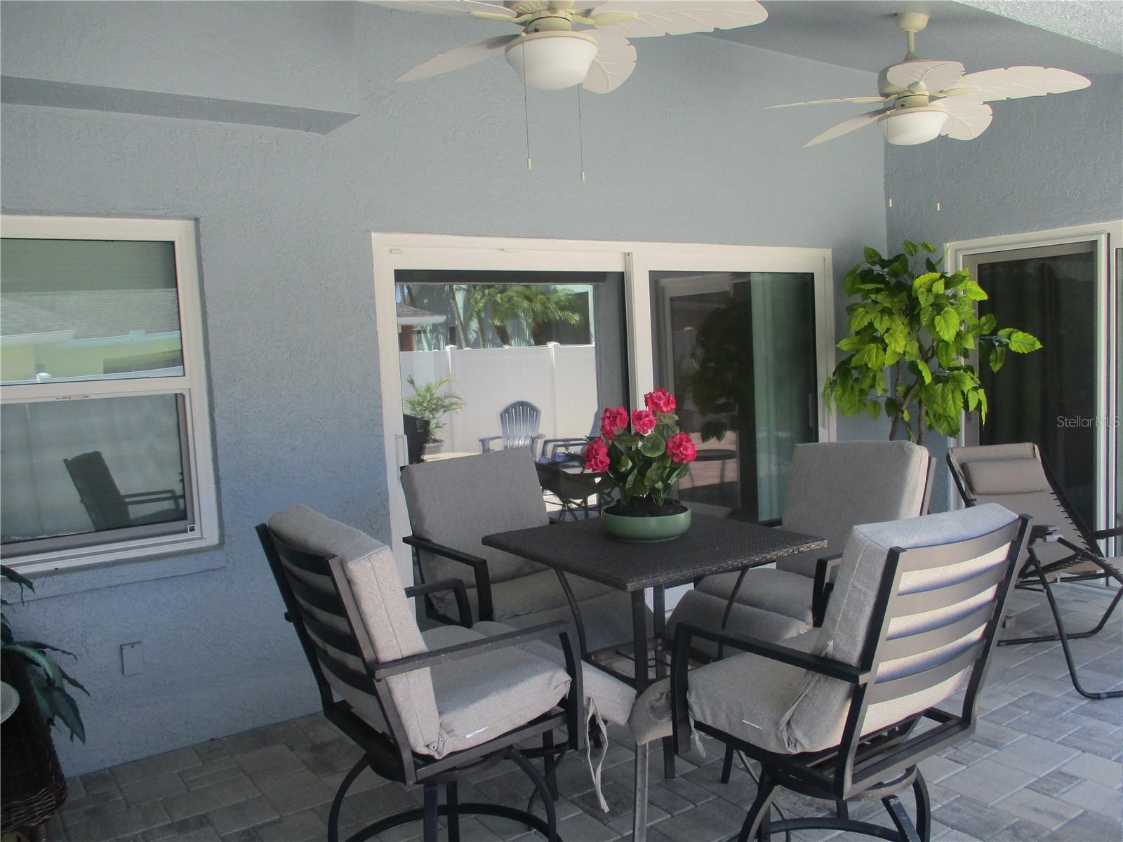 STORM SLIDING DOORS FROM THE LIVING AREA AND THE PRIMARY BEDROOM LEAD OUT TO THE NEWLY PAVED PATIO.