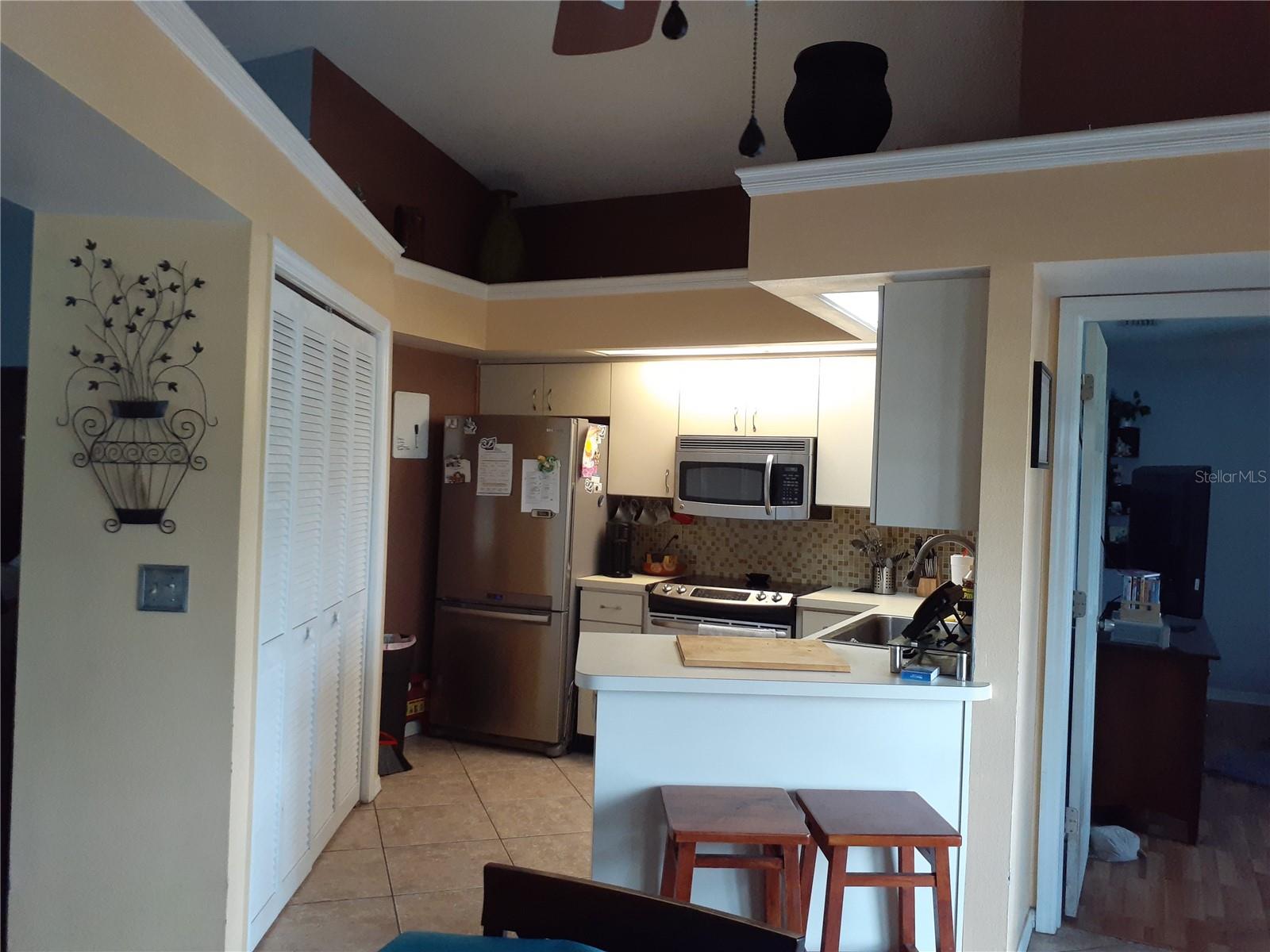 Kitchen with stainless steel appliances, plant shelf and large pantry