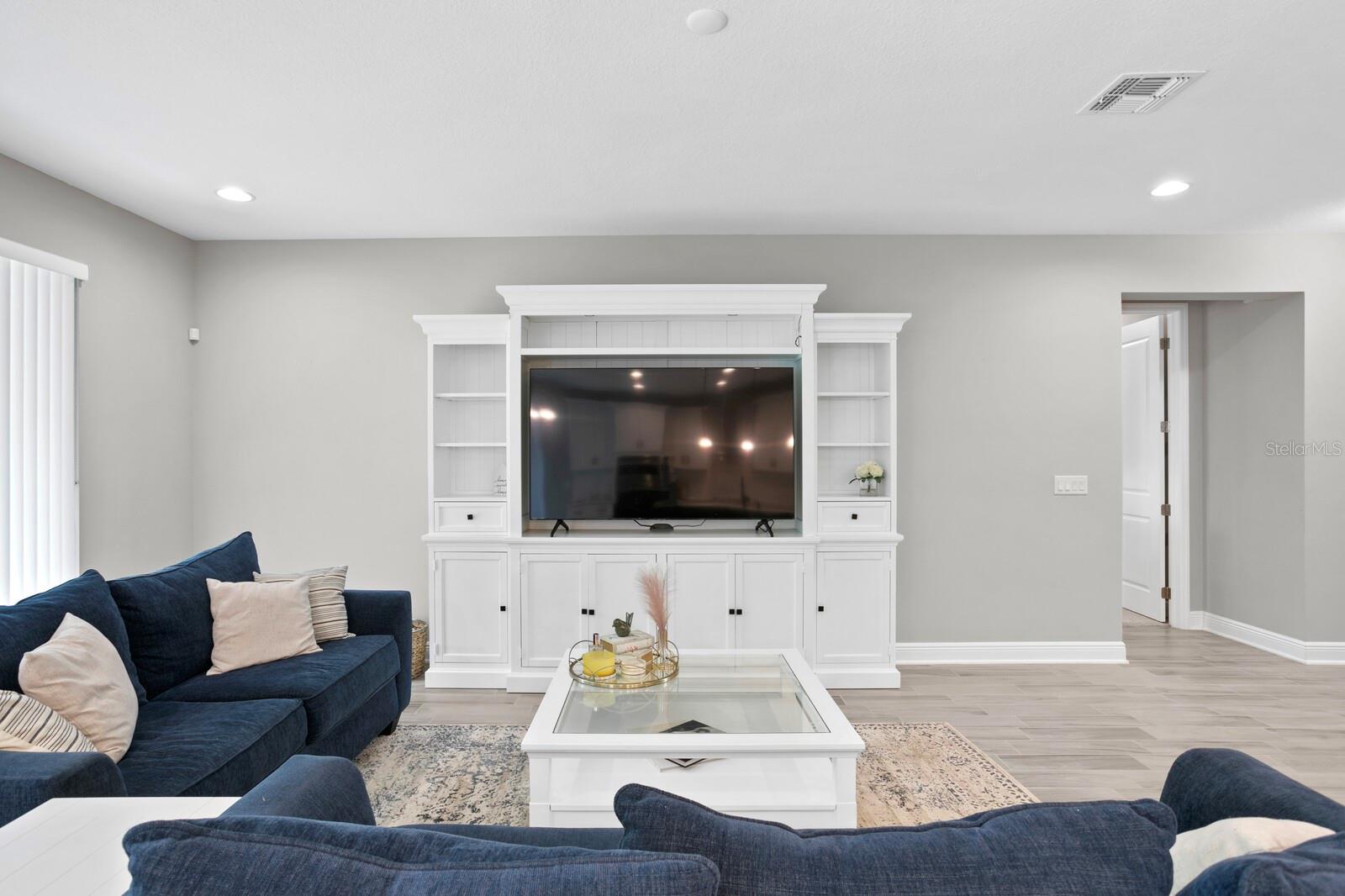 Ample room for an entertainment center, seating, and accessible to the kitchen and backyard.