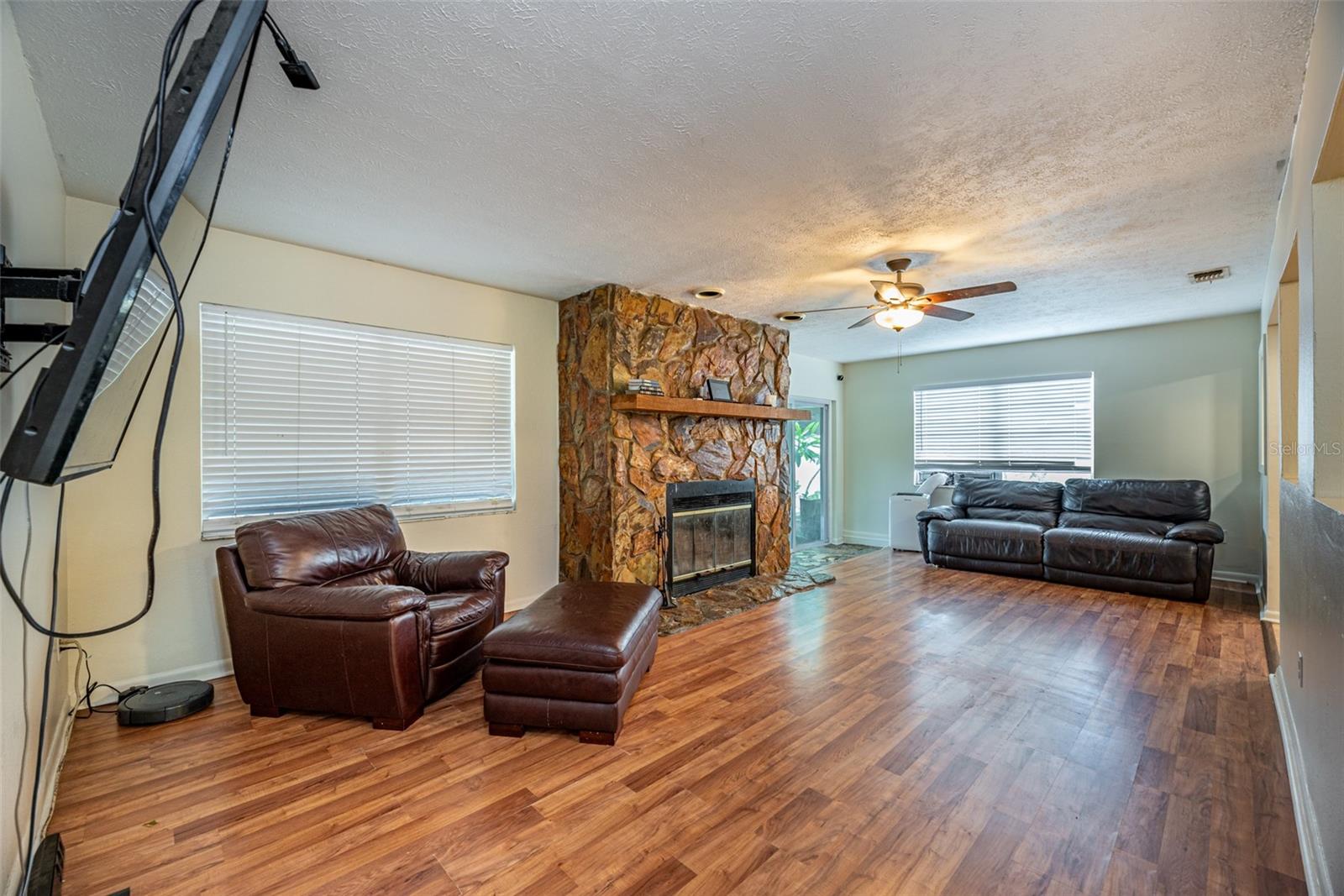 This spacious Living room has a stone, wood burning fireplace as its focal point.