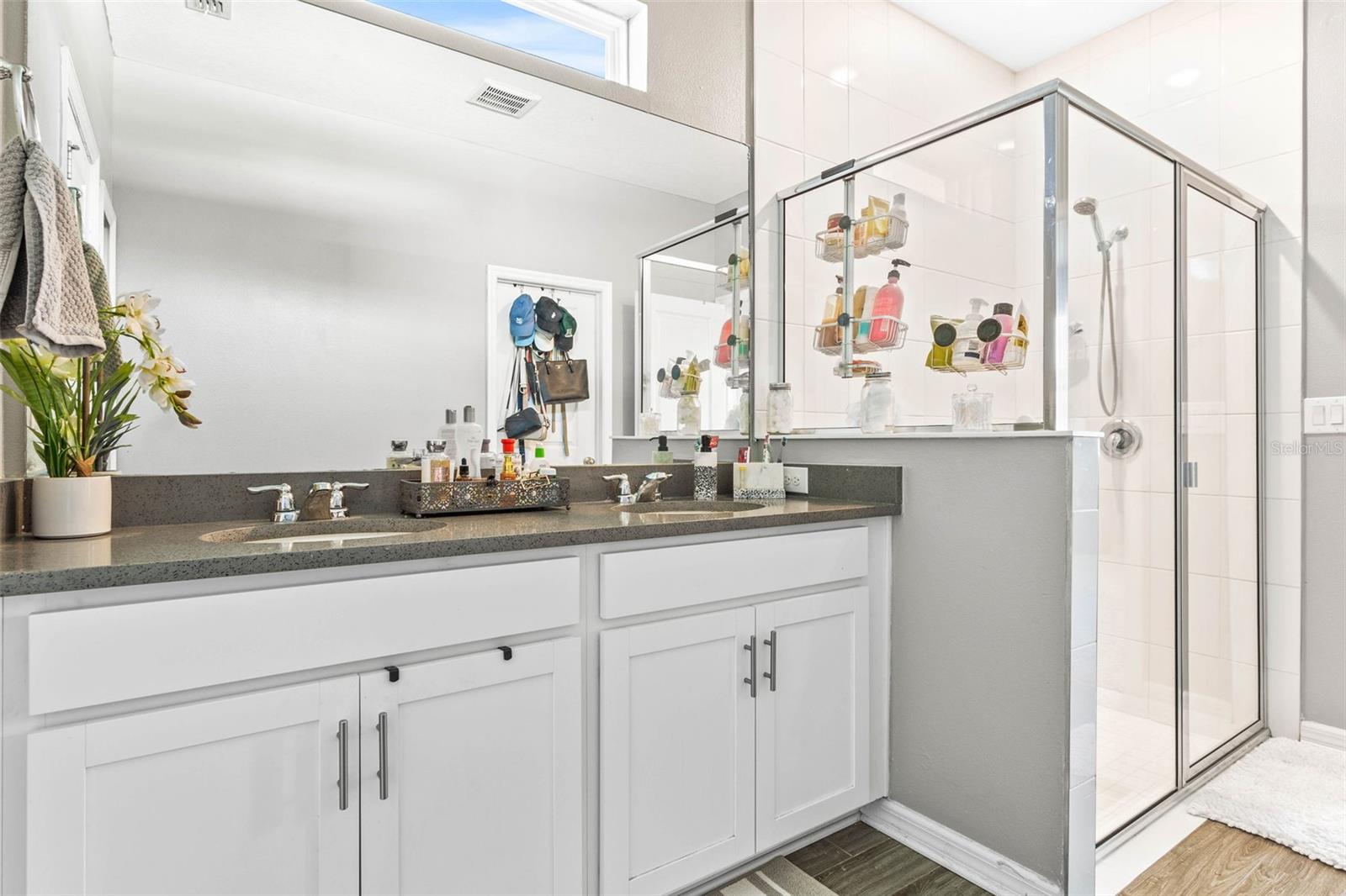 Primary ensuite bathroom with walk-in shower. Walk in closet to the left of the vanity.