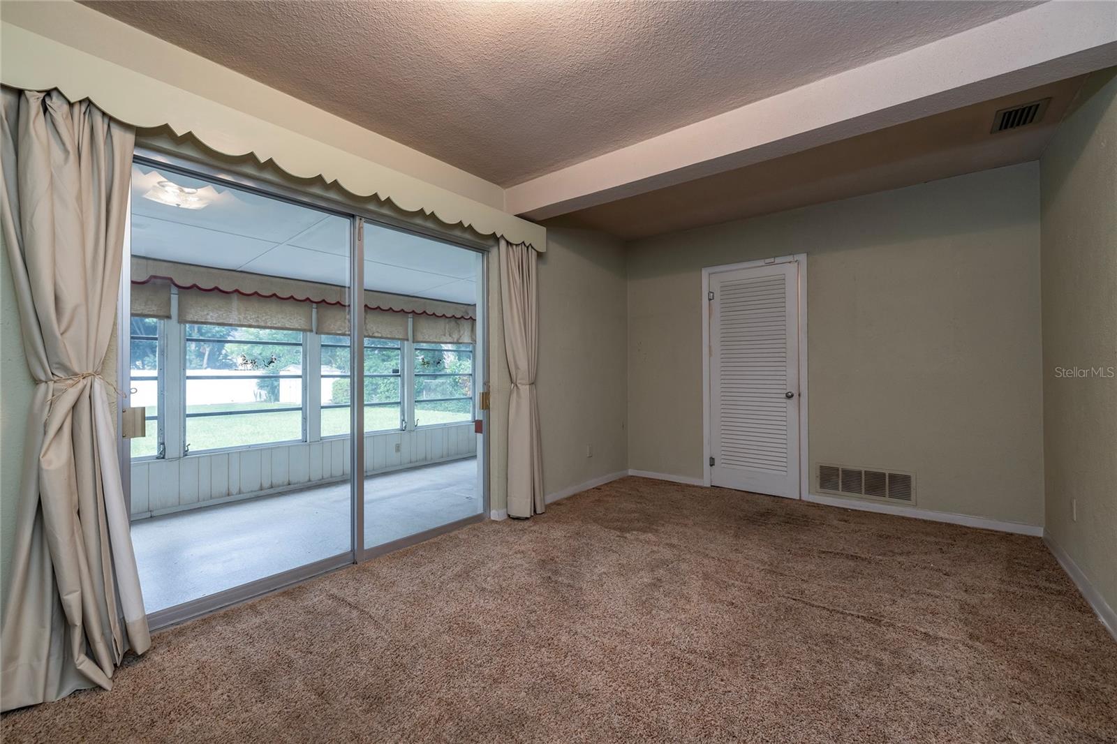 Dining Room with large closet and sliders to Florida Room