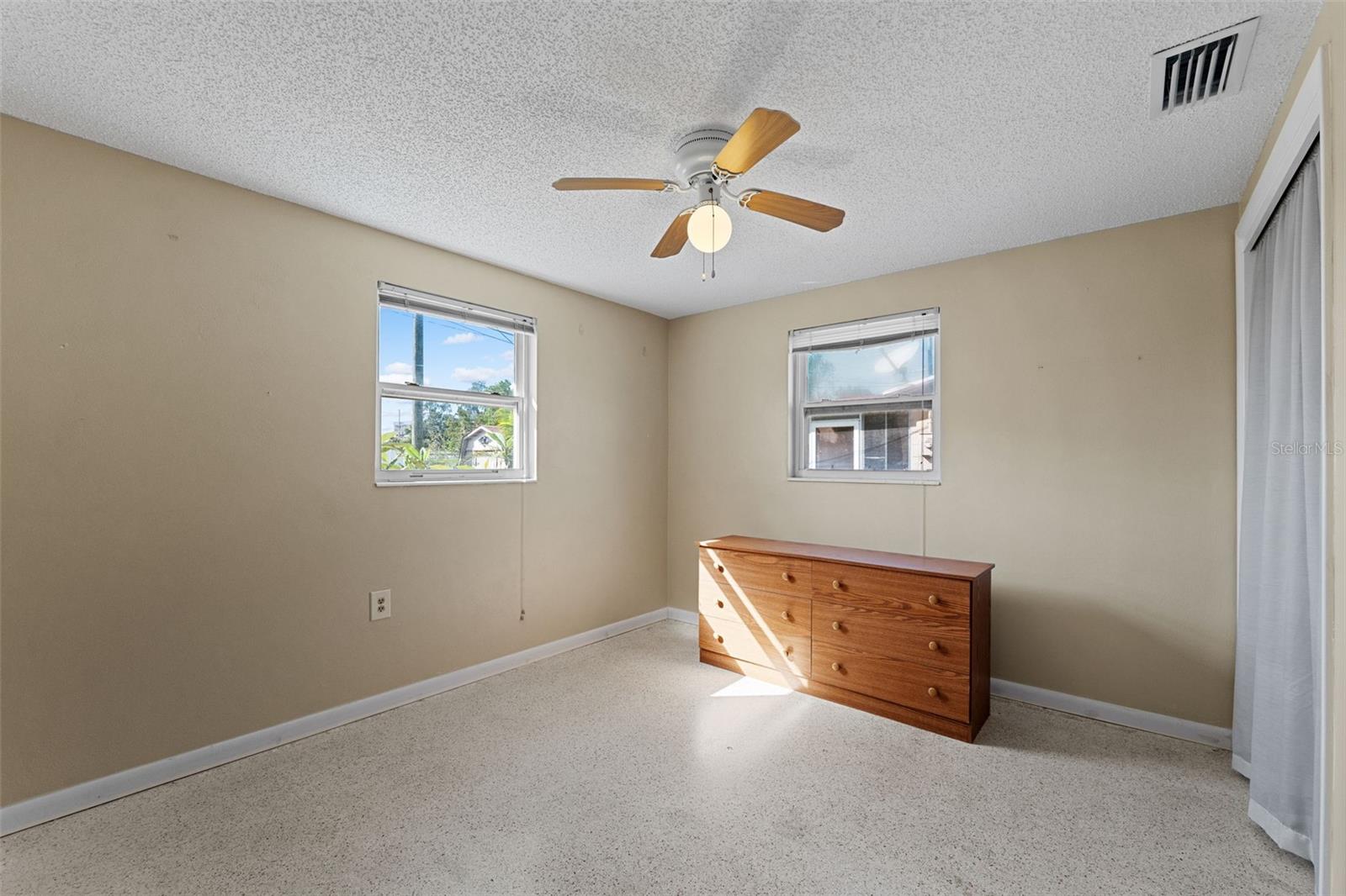 Two large windows provide a lot of light in this second bedroom