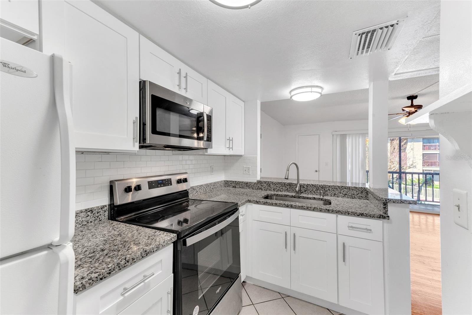 Upgraded kitchen with sight lines to Living room and balcony.