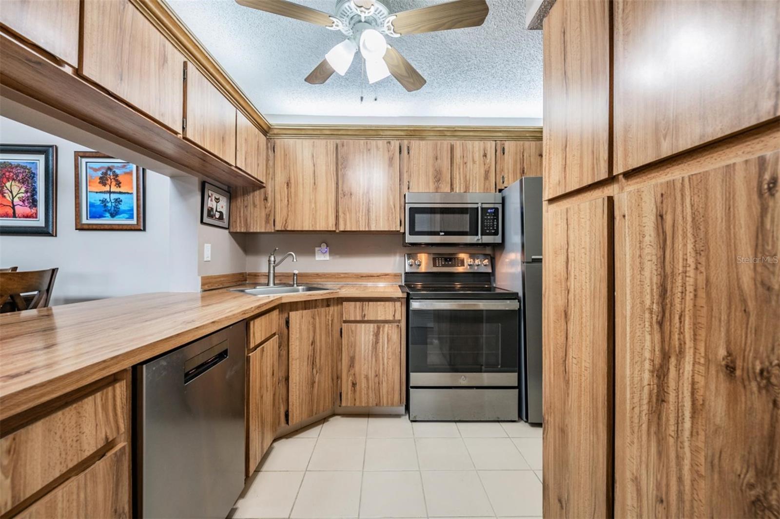 The kitchen is well-equipped with stainless steel appliances, a pantry, and plenty of cabinets and counterspace.