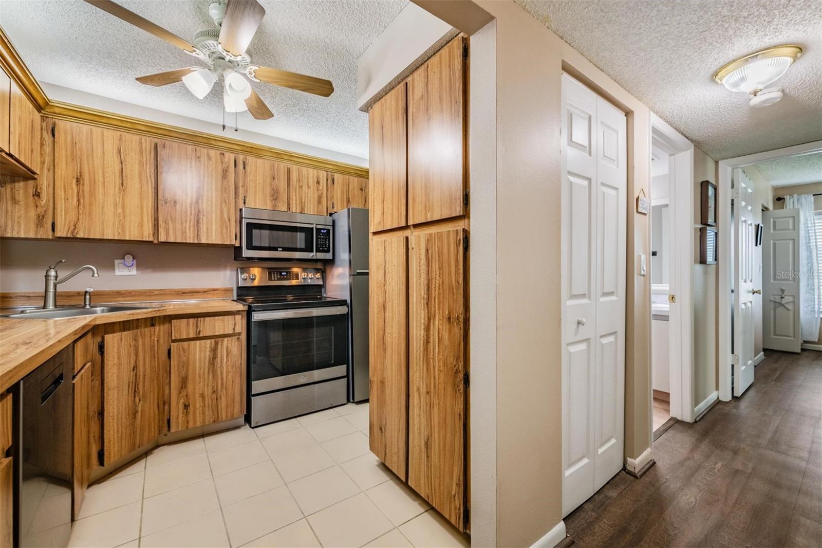 The kitchen is well-equipped with stainless steel appliances, a pantry, and plenty of cabinets and counterspace.