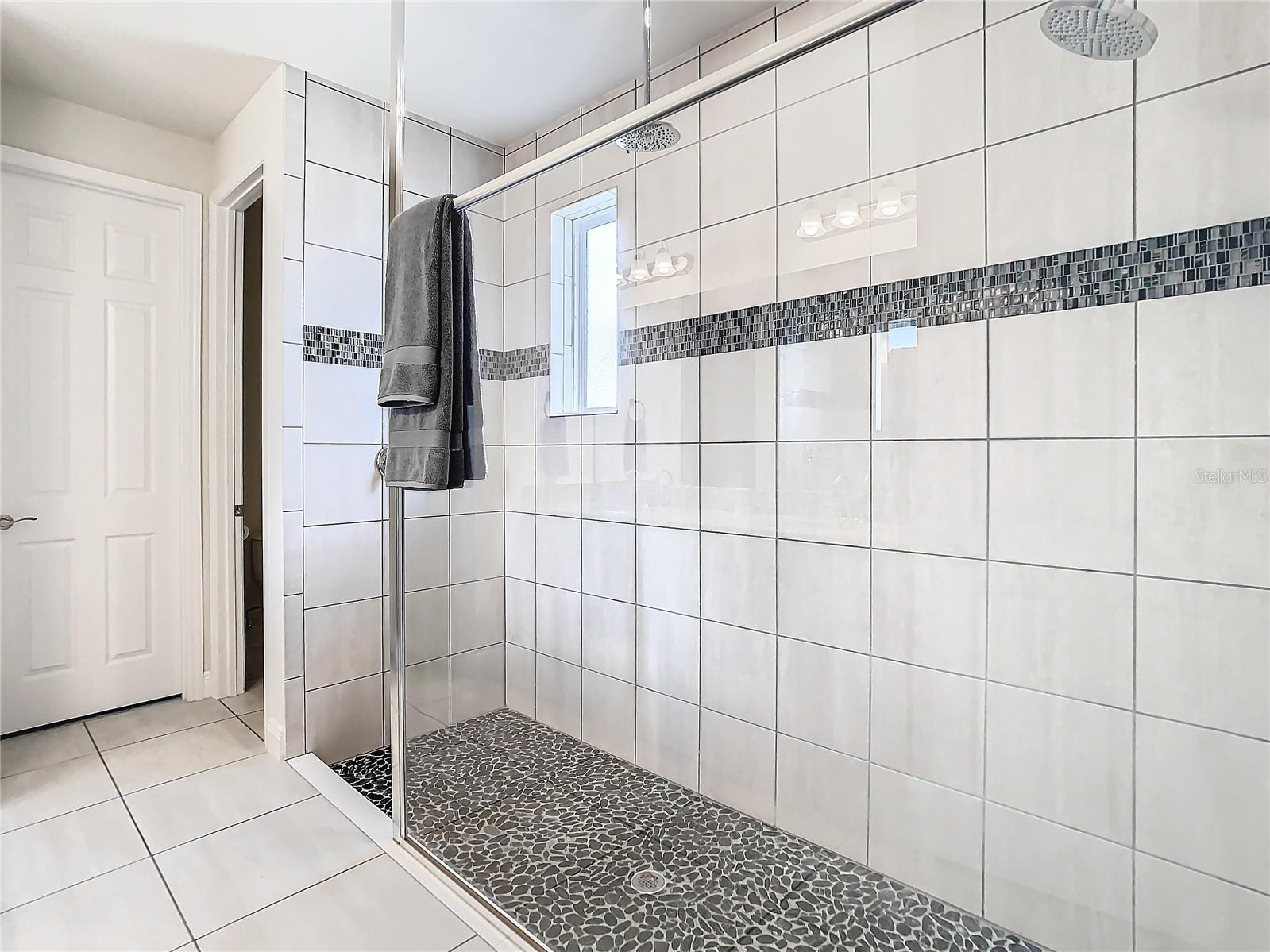 Primary Bathroom has huge shower with dual showerheads.